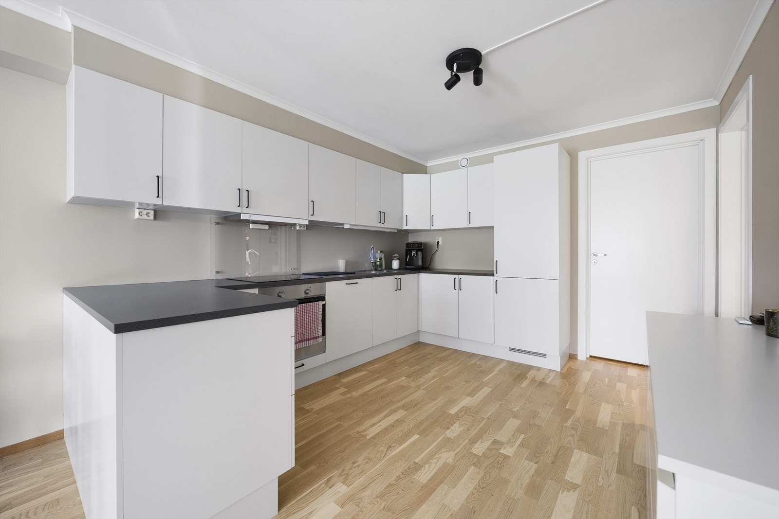 Kjøkkenet ligger i en sosial åpen løsning mot stuen. Pen Marbodal kjøkkeninnredning med slette fronter og laminert benkeplate Galleribilde