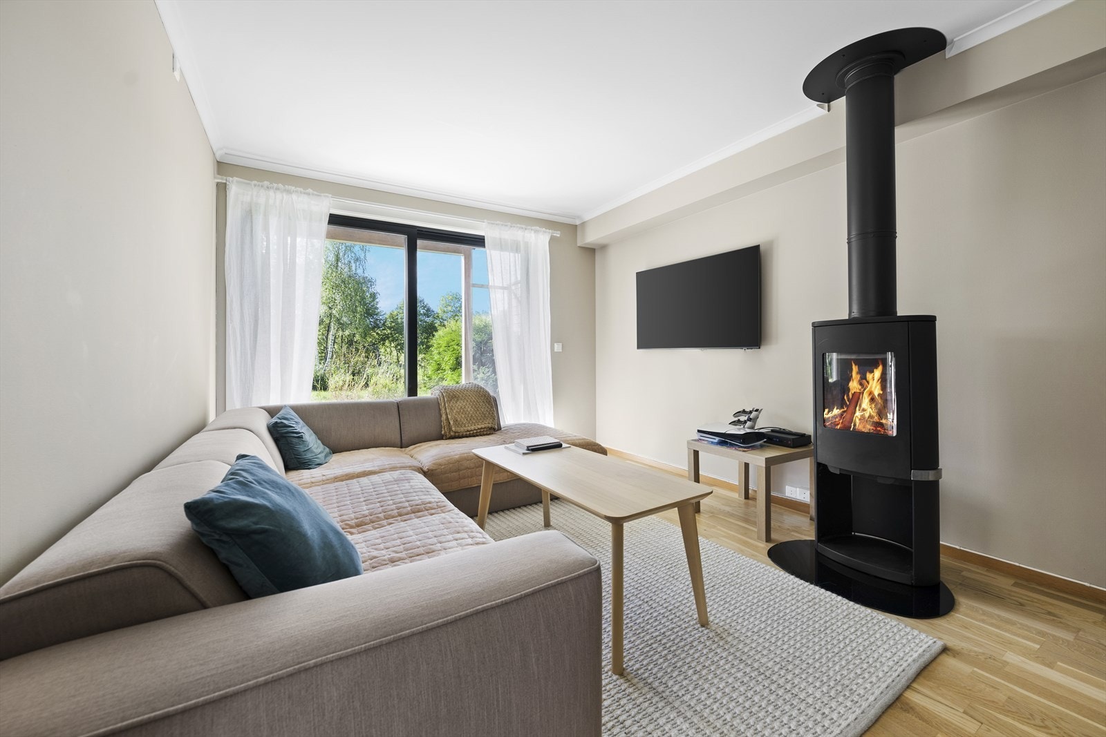 Lys stue med god plass til sofagruppe og tilhørende møblement Galleribilde