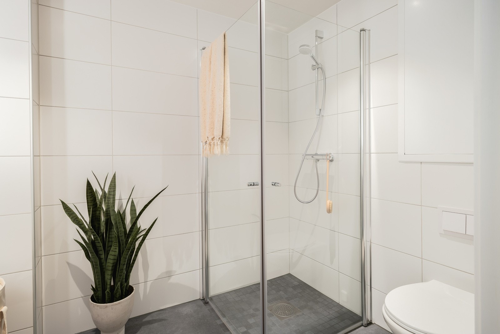 Badet er videre utstyrt med servant med innredning fra HTH, vegghengt toalett og dusjnisje med glassdør. Galleribilde