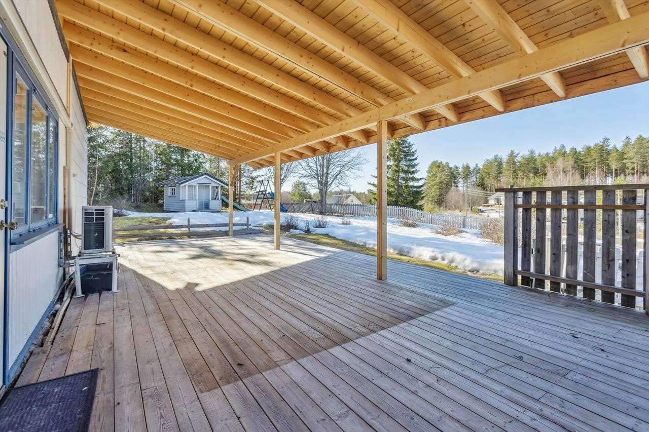 Stor, vestvendt terrasse med takoverbygg utenfor stue Galleribilde