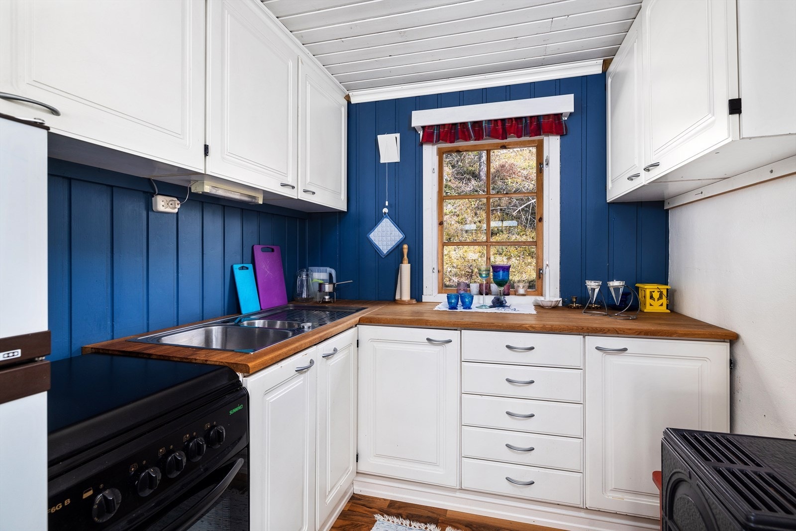 Kjøkkenet har en lys innredning med profilerte fronter og benkeplaten er av heltre. Galleribilde