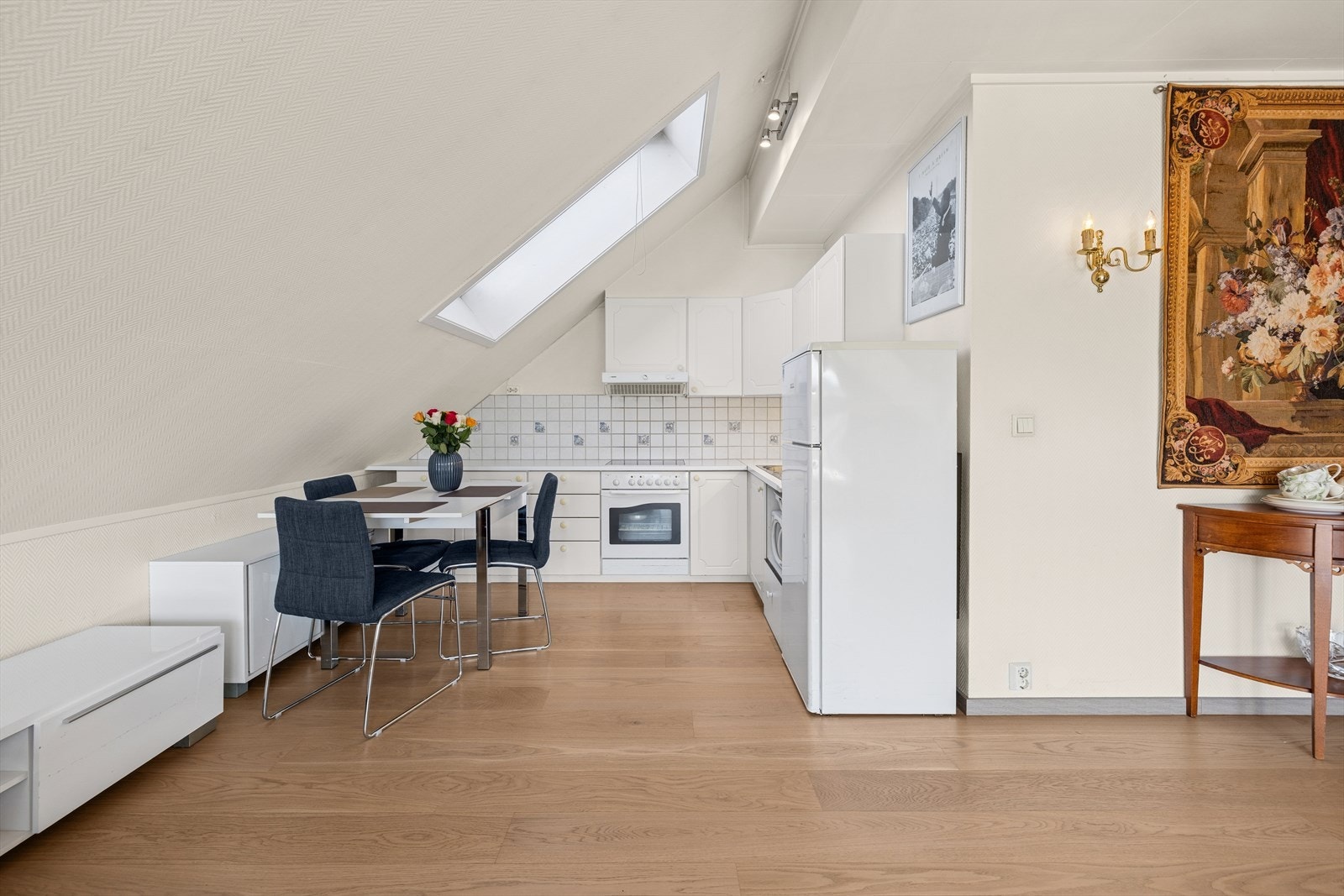 Kjøkkeninnredningen er fra 2002 og er pent utført med hvite, profilerte fronter og benkeplate i hvit laminat med nedfelt kum. Galleribilde