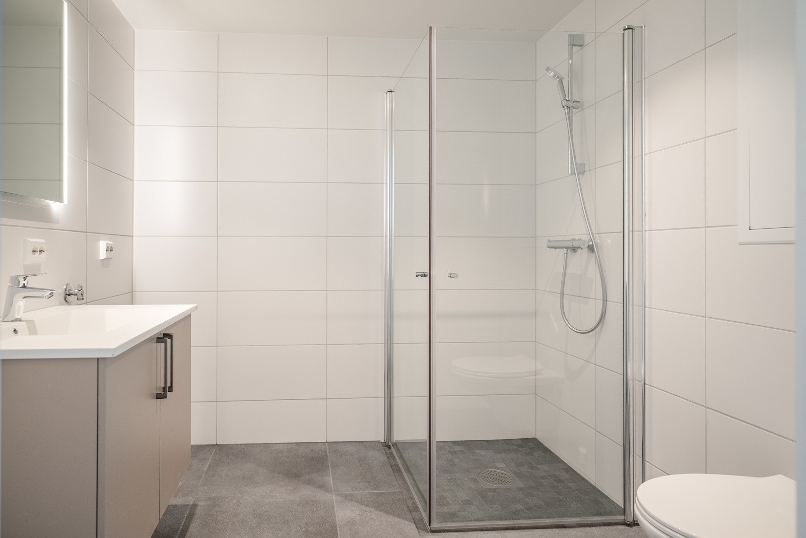 Lyst og flislagt baderom med varmekabler i gulv. Galleribilde