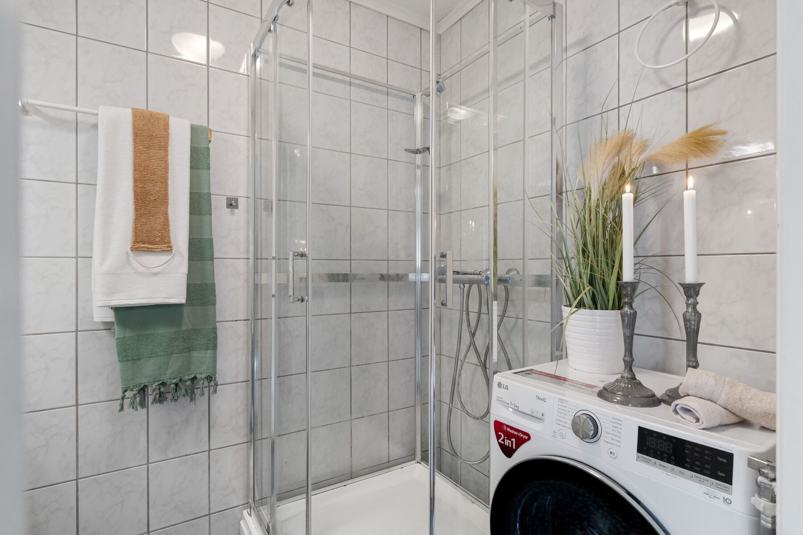 Badet er utstyrt med dusjkabinett, opplegg for vaskemaskin, toalett og servant med innredning. Galleribilde