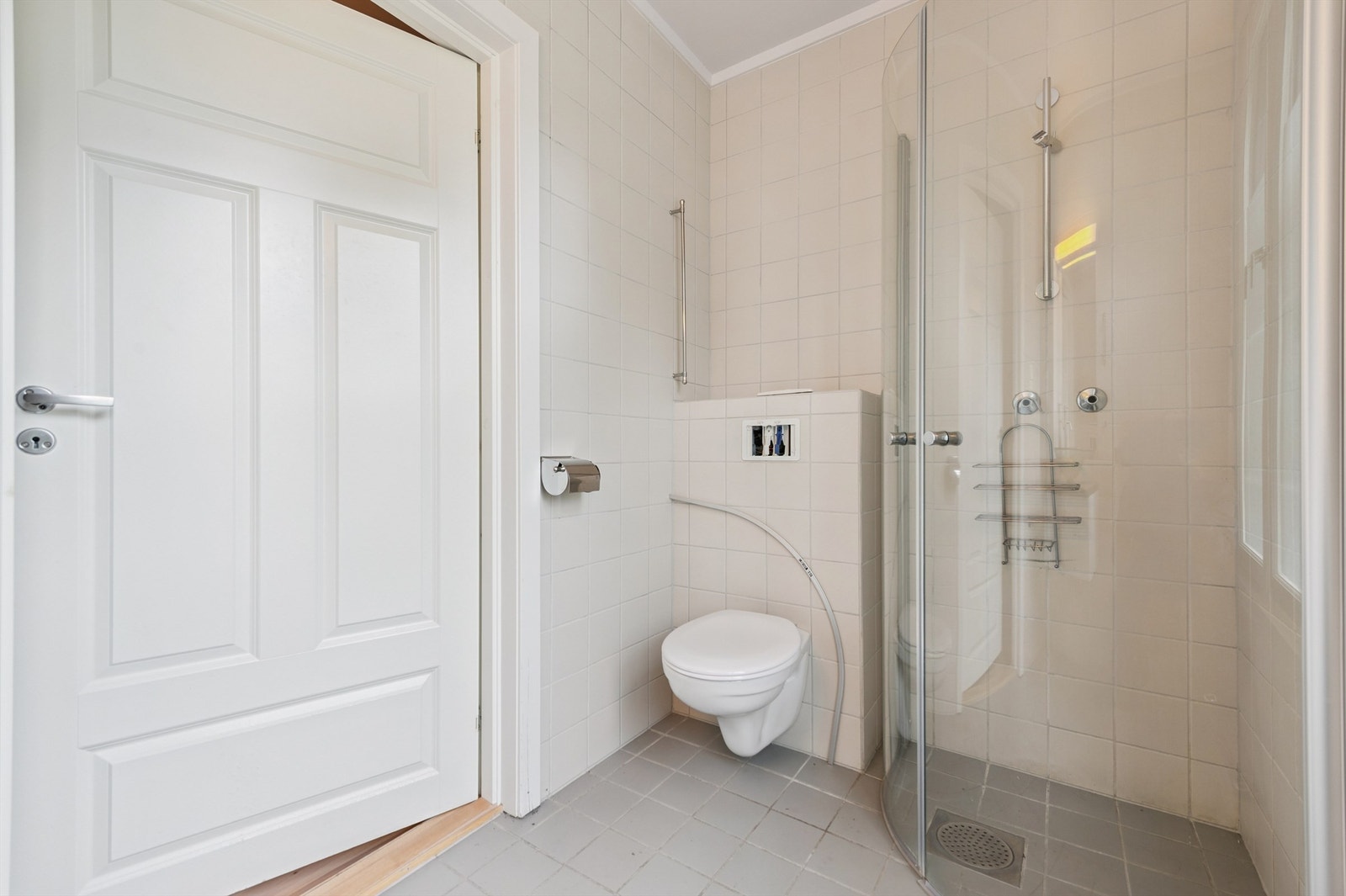 Her er det dusjhjørne med buede glassvegger og et vegghengt toalett. Galleribilde