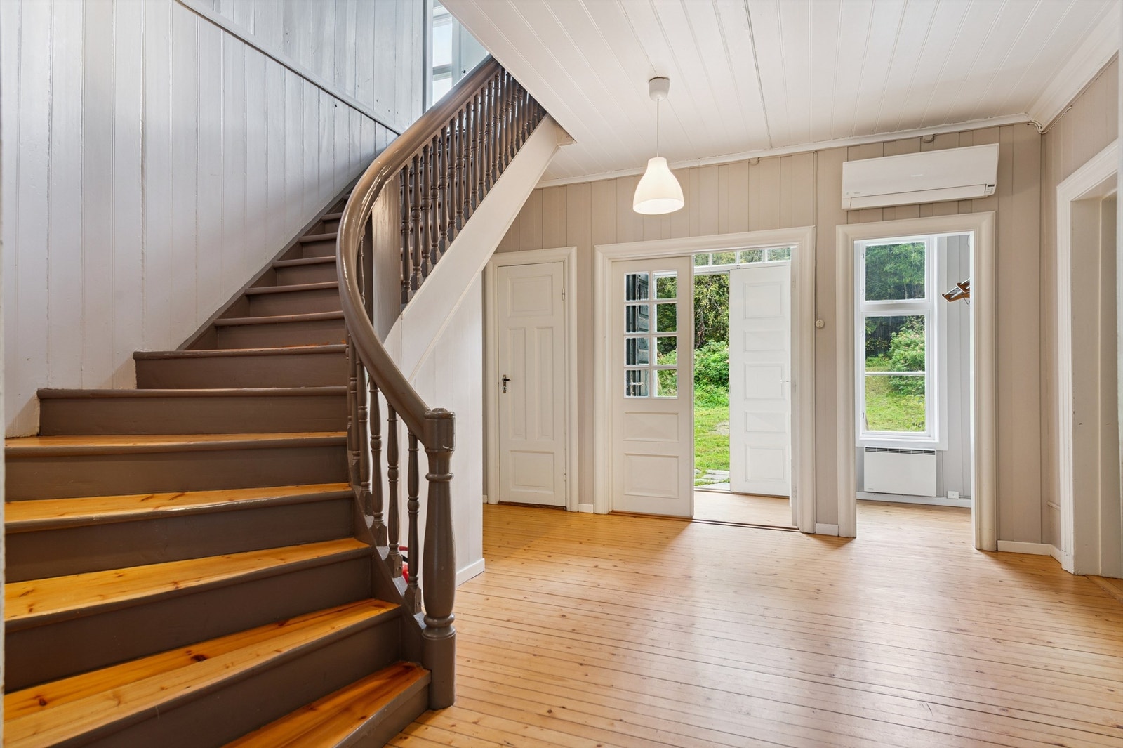 Fra hallen fører en flott tretrapp opp til andre etasje. Legg merke til luft-til-luft varmepumpen fra 2010. Galleribilde