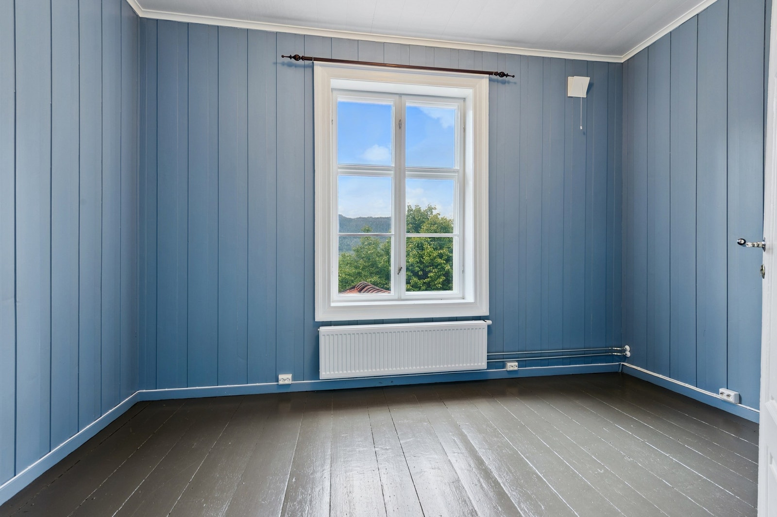 Et lyst og trivelig rom med en fin fargepalett og panelvegger. Galleribilde