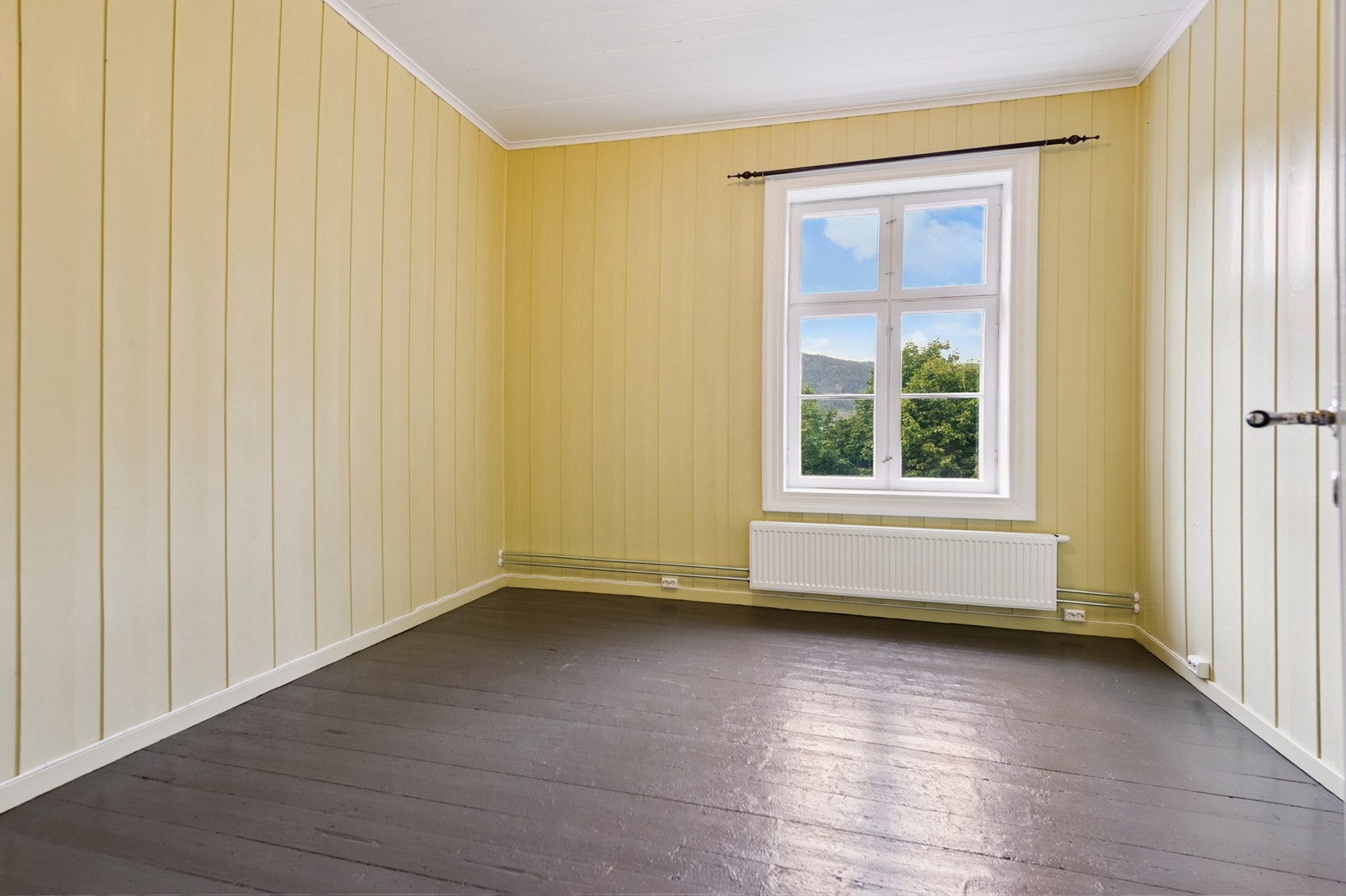 Dette soverommet har panel på veggene og plass til både seng og arbeidsområde. Galleribilde