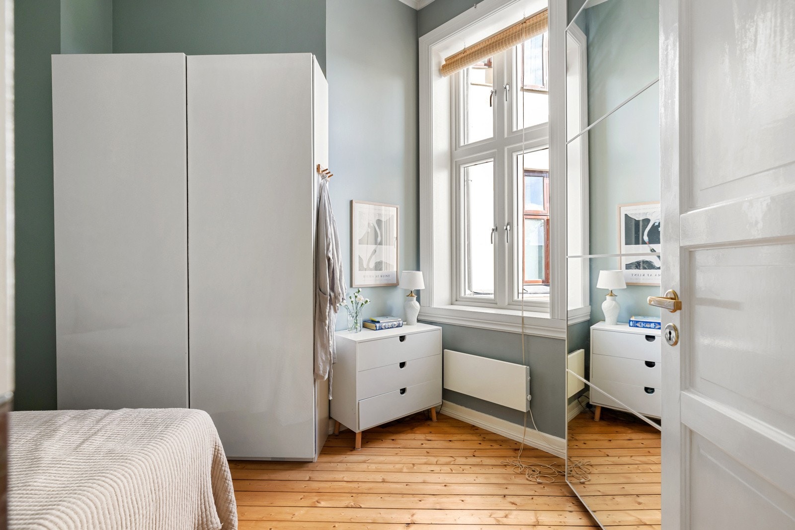 Rommet er innredet med to store garderobeskap, ett med speildører og den andre med hvite overflater. Galleribilde