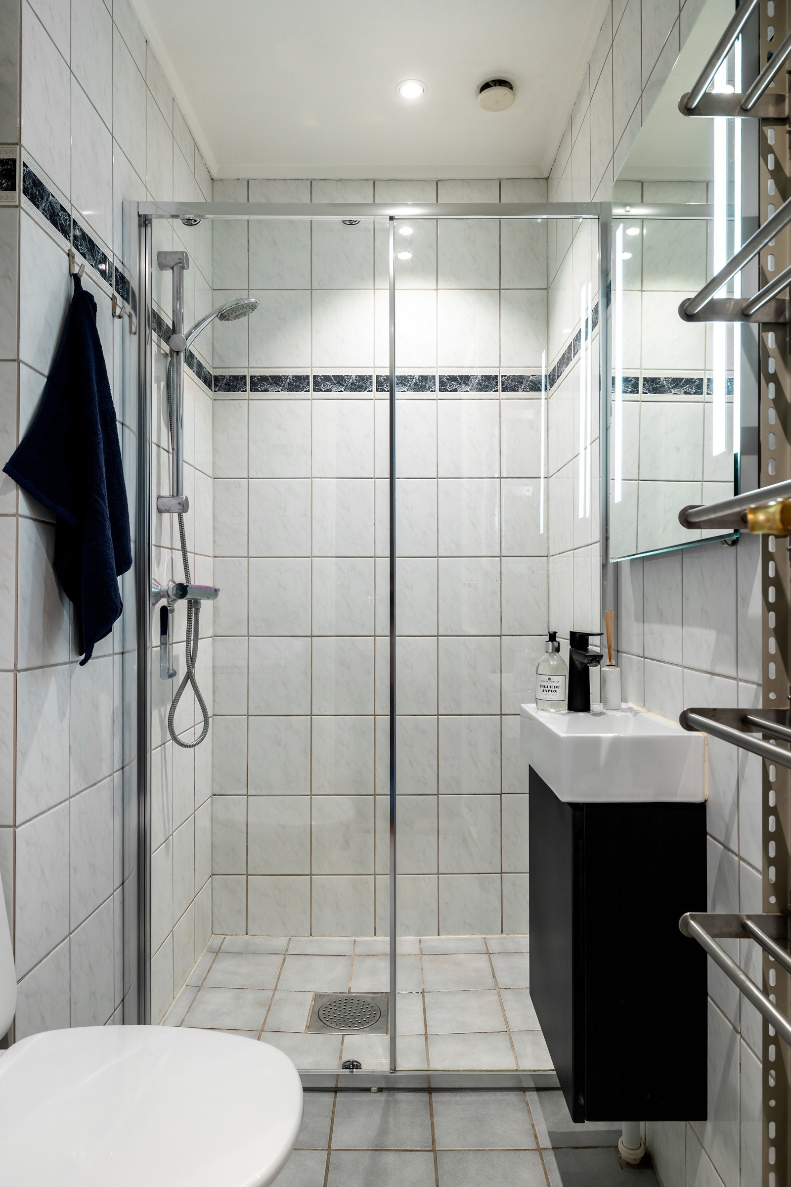 Det er innredet med dusjhjørne med glassdører, vegghengt servantskap med servant og speil med belysning som gir godt lys. Rommet er utstyrt med toalett og vaskemaskin. Galleribilde