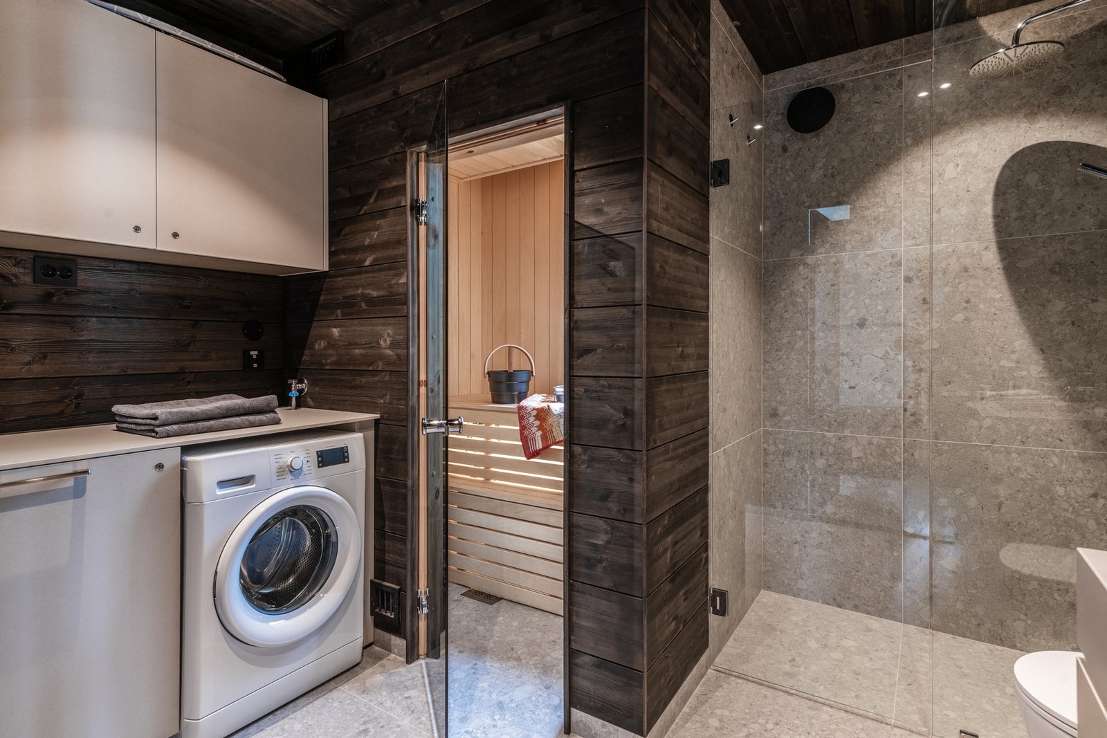 Bad med vaskemaskin og inngang til sauna Galleribilde