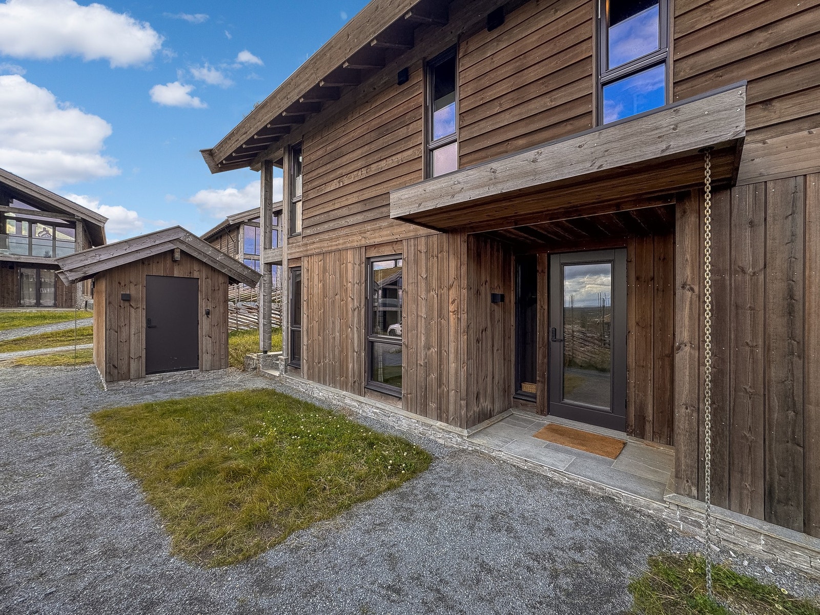 Hytten går over to etasjer og har inngang fra bakkeplan og utvending sportbod Galleribilde