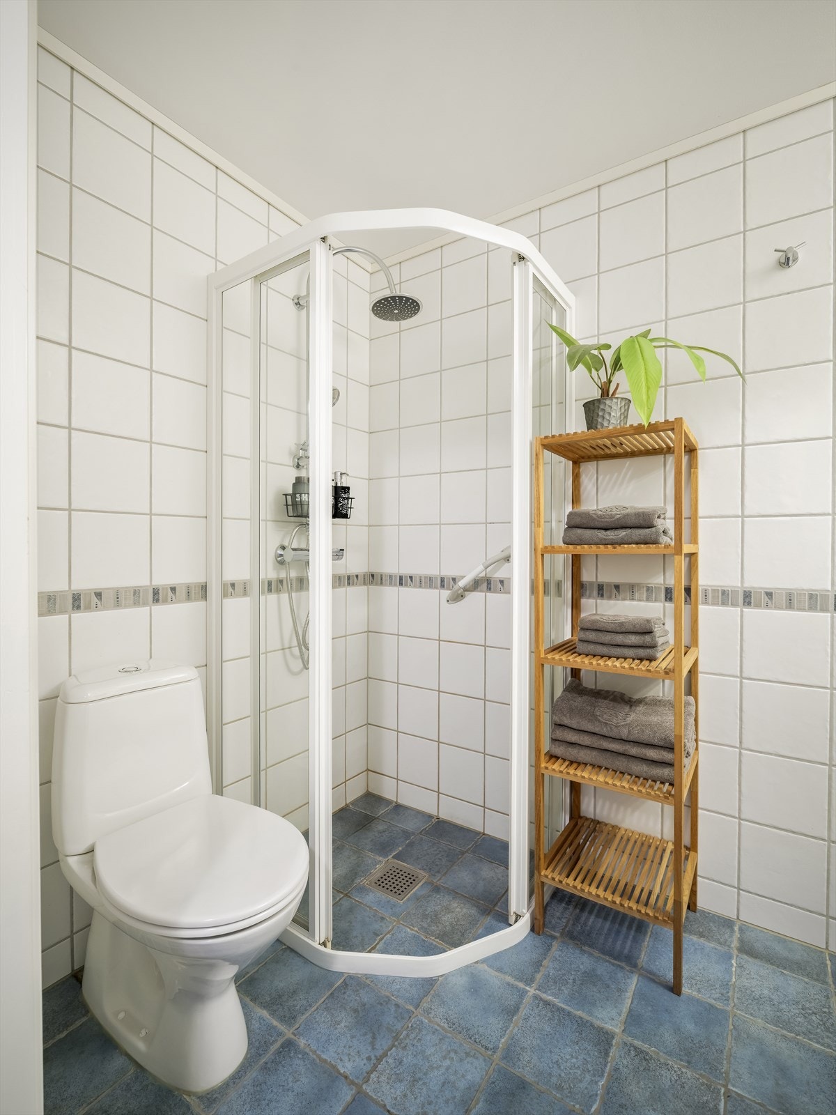 Baderommet er også utstyrt med dusjhjørne med regnfallsdusj og gulvstående toalett. Baderommet har fliser på gulv og vegger, deilig gulvvarme og mekanisk avtrekk. Galleribilde