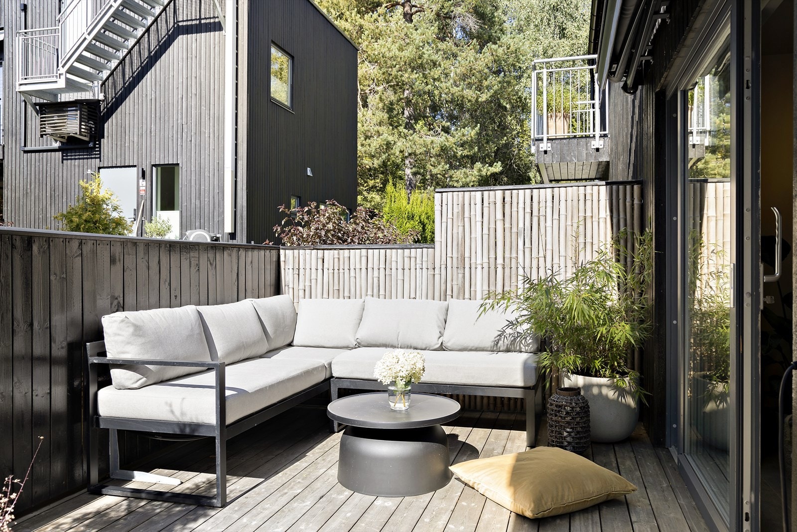 Terrassen er kledd med kebony terrassebord og er skjermet med levegger mot fellesareal Galleribilde