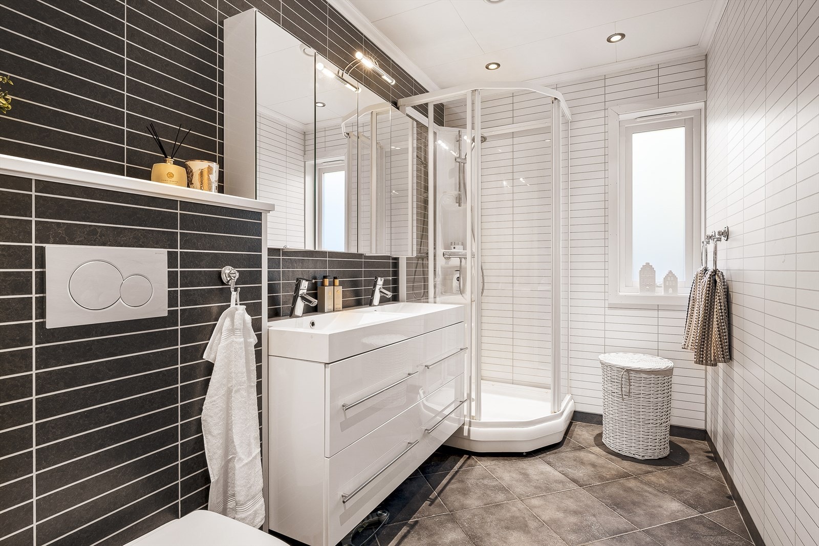 Badet i 1.etasje måles til 4,9m² og ble oppgradert i 2009 med moderne kvaliteter. Her får du dobbeltservant med møblement og speil med belysning, vegghengt toalett og dusjkabinett. Galleribilde
