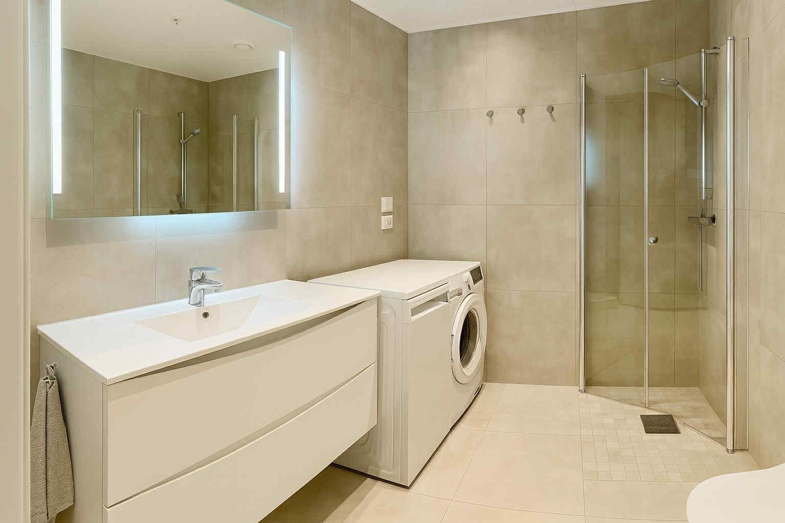 Badet er lyst og romslig med tidløse fliser på vegger og gulv. Galleribilde