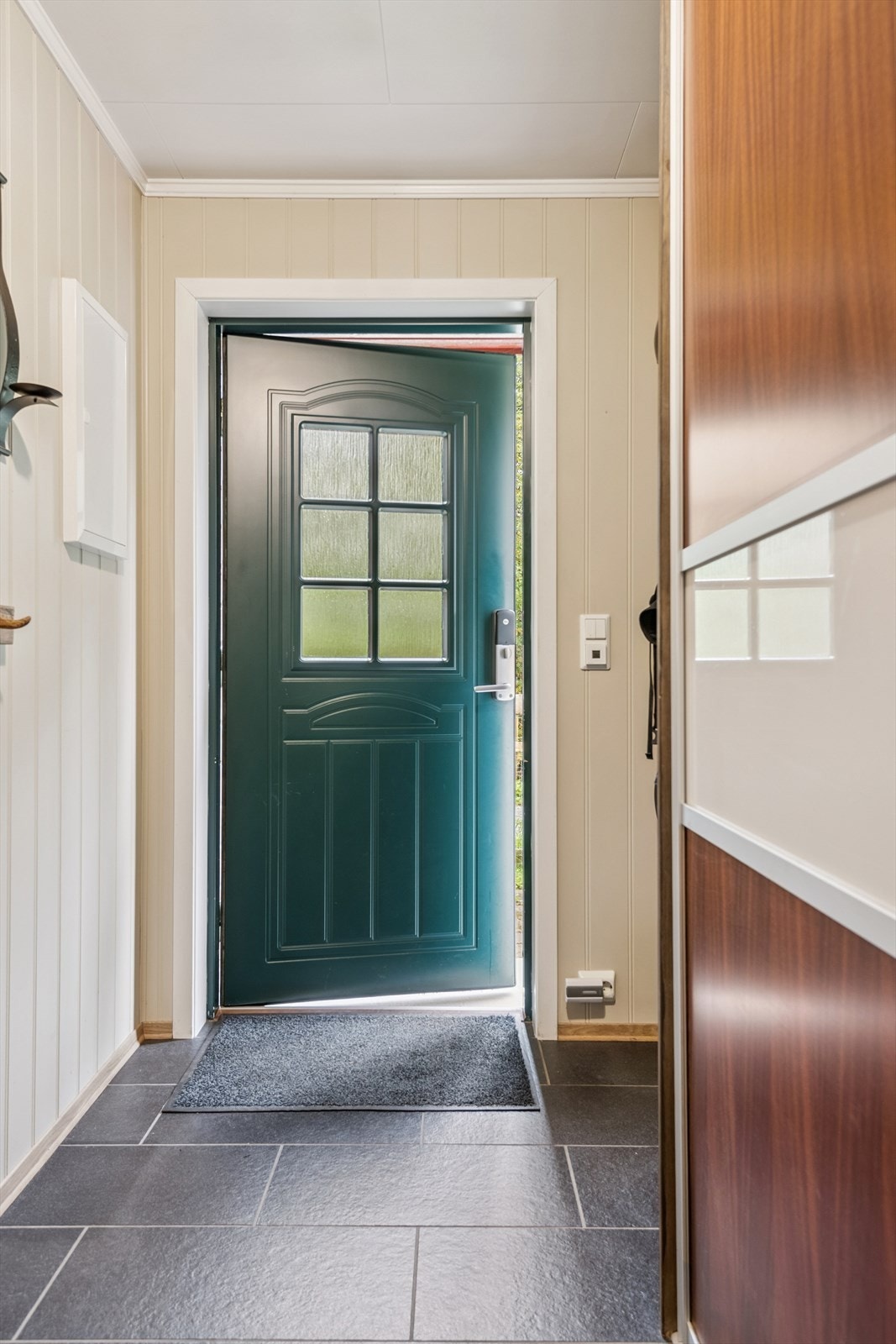 Velkommen inn. Entréen har et praktisk, flislagt gulv med garderobe løsning. Entréen leder deg videre inn i boligens hoveddel. Galleribilde