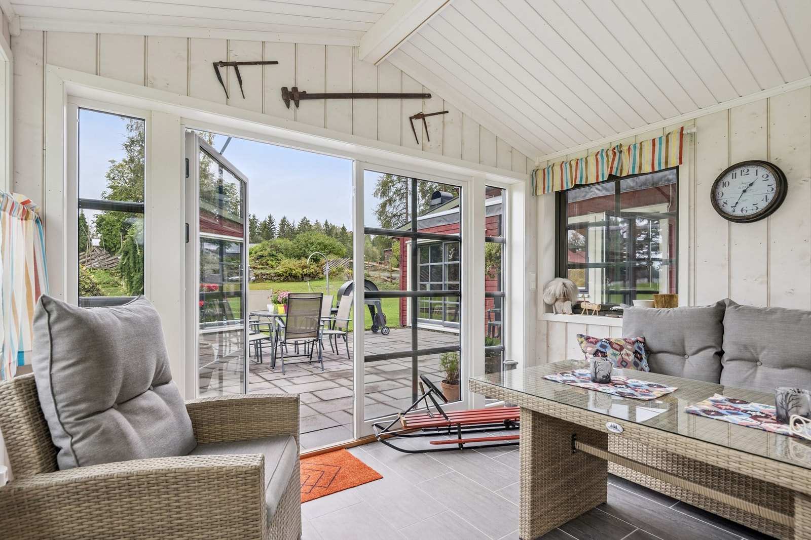 Dobbeltdørene kan åpnes helt opp og knytter hagestuen sammen med den steinlagte terrassen. Galleribilde