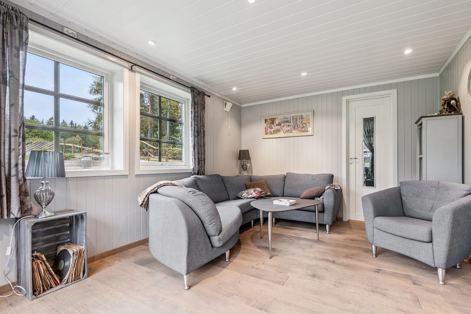 Stuen er et lyst rom med parkett på gulvet og plass til en større sofagruppe. Galleribilde