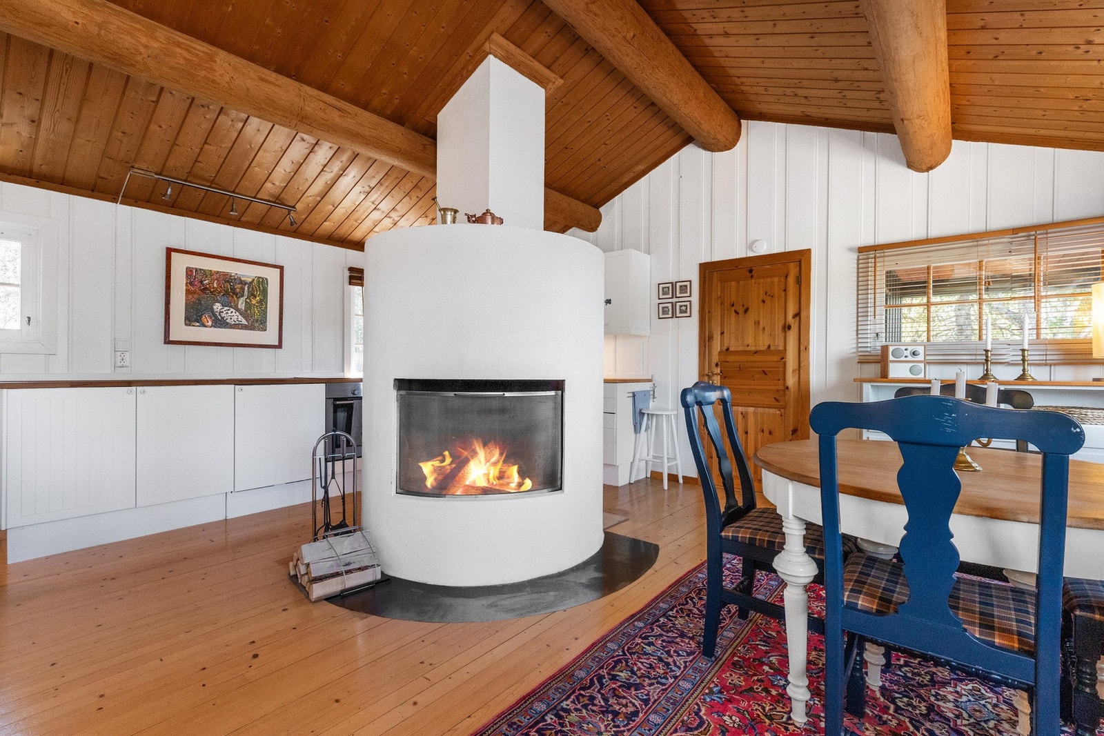 Flott peis som deler inn rommet noe, denne gir en lun og god varme samt en hyggelig atmosfære til rommet Galleribilde