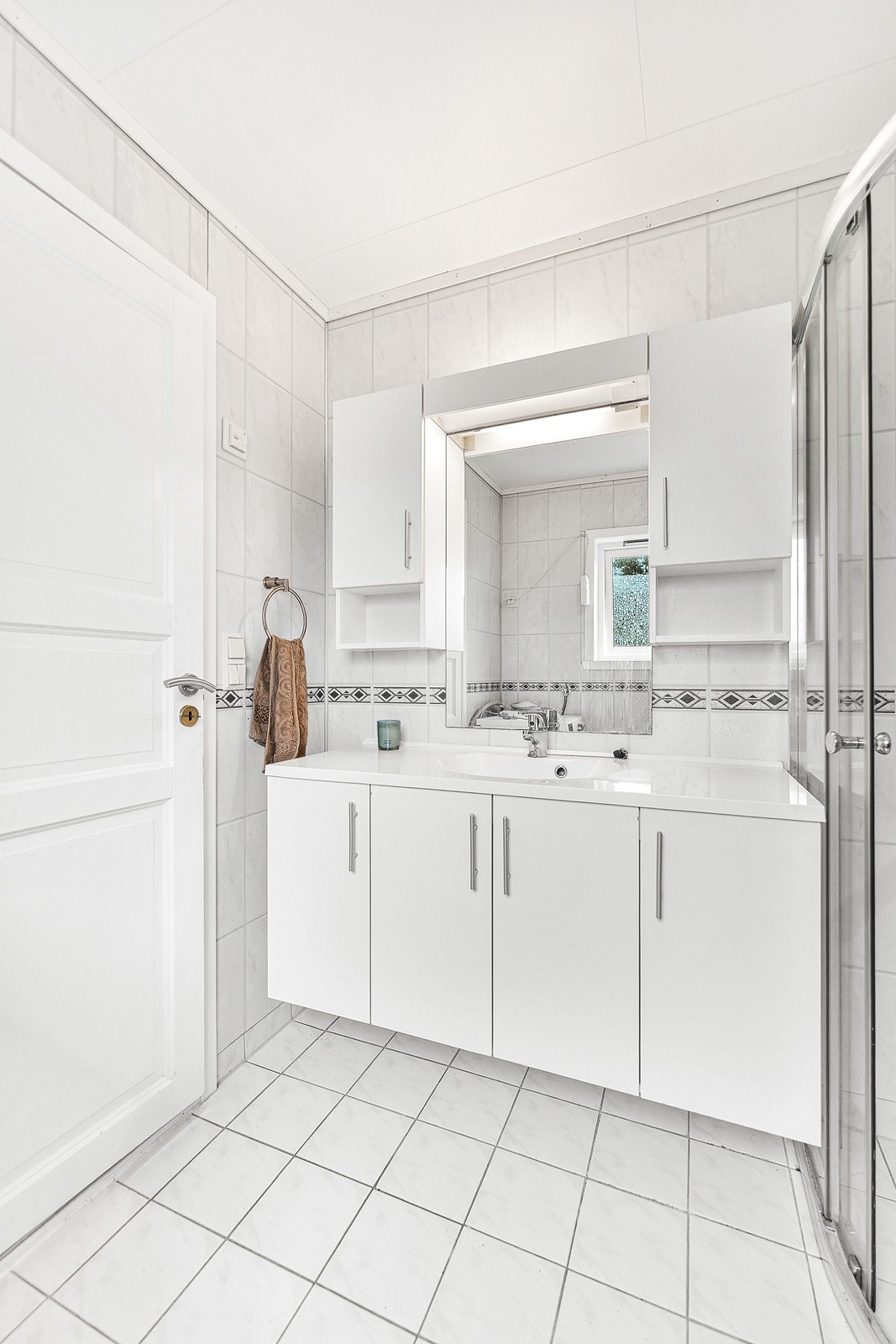 Eldre baderom med fliser på gulv og baderomsplater på veggene. Galleribilde