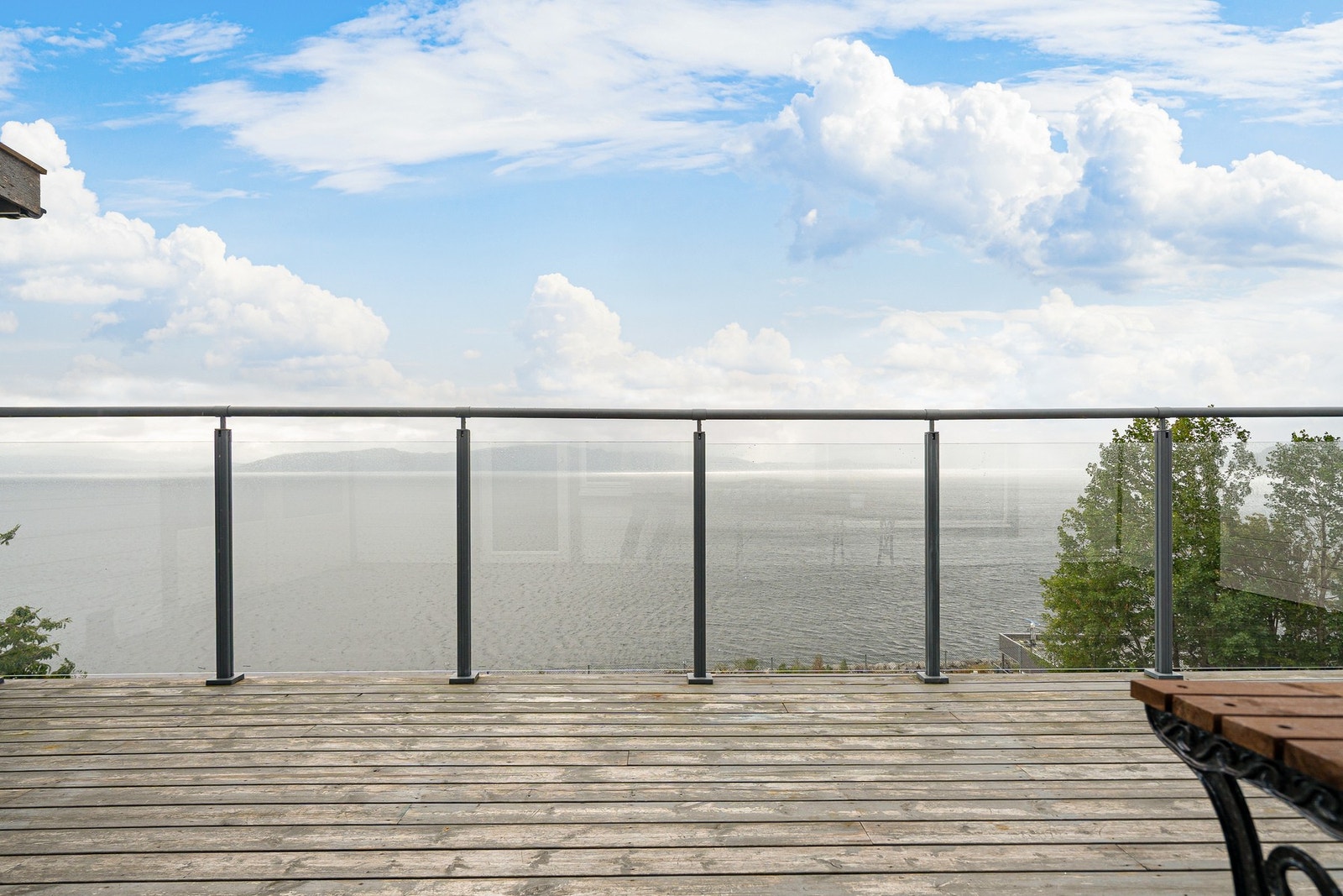 Stor og romslig veranda med glassrekkverk. Det må man jo bare ha når man er så heldig å ha denne sjøutsikten. Galleribilde