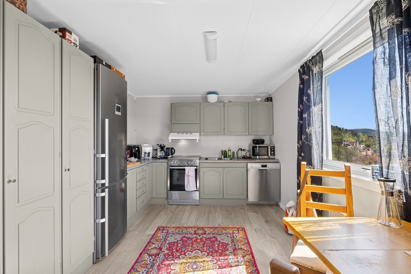 Kjøkken med profilerte fronter og frittstående hvitevarer. Galleribilde