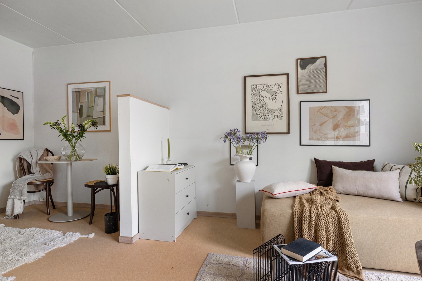 Leiligheten har naturlige soner for møblering, med en skillevegg mellom sofahjørne og spisebord. Galleribilde