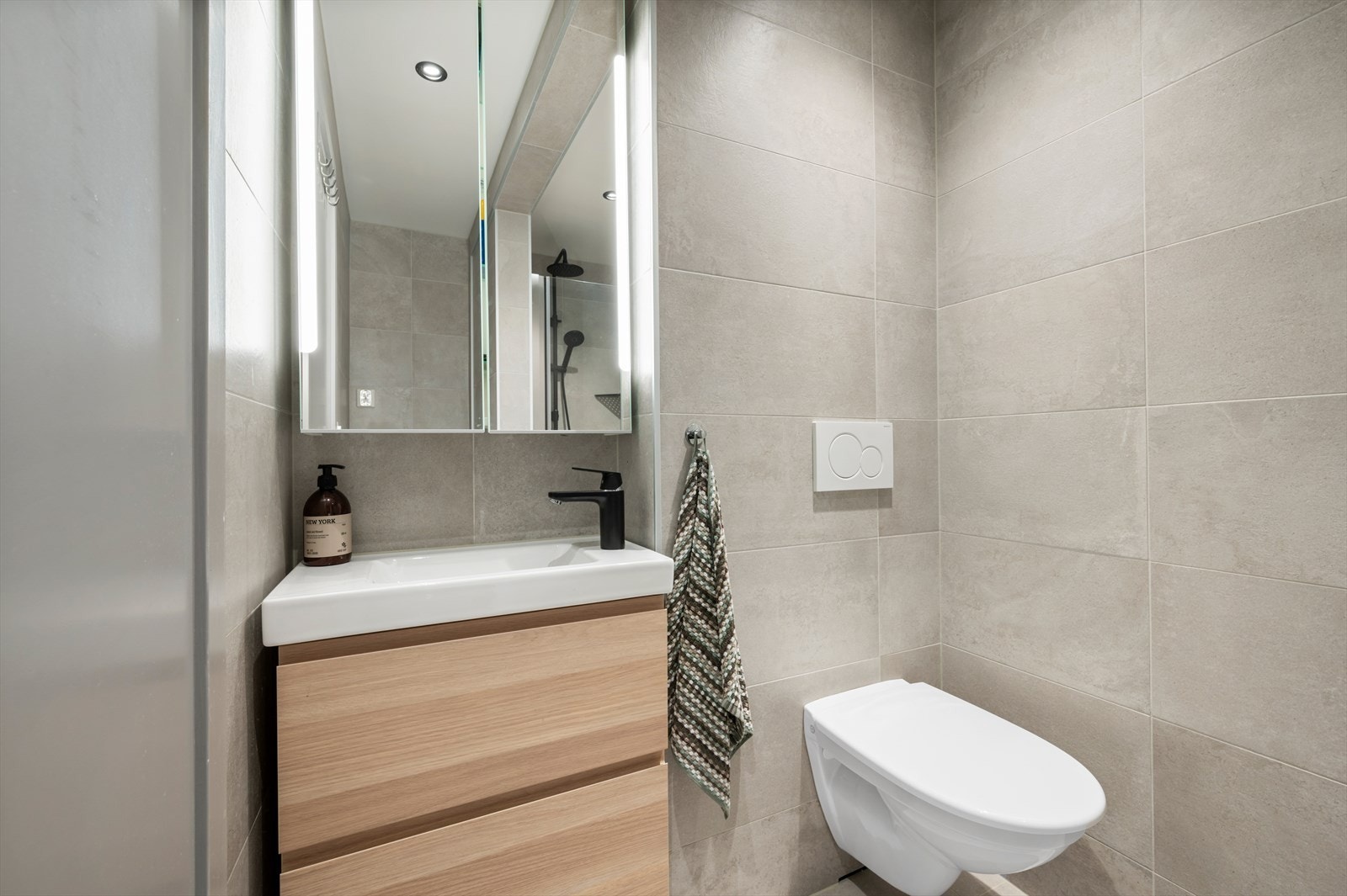 Badet er utstyrt med servantskap, mekanisk avtrekk, opplegg for vaskemaskin, veggmontert wc og dusjnisje. Galleribilde