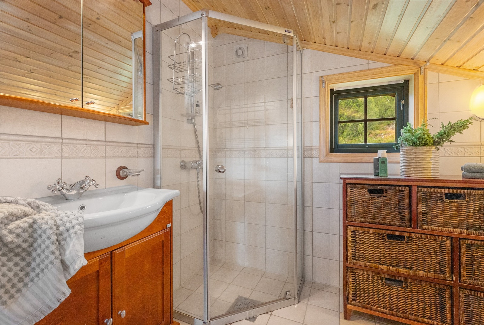 Badekar og dusj med svingbare glassvegger, toalett og enkel innredning med nedfelt servant Galleribilde