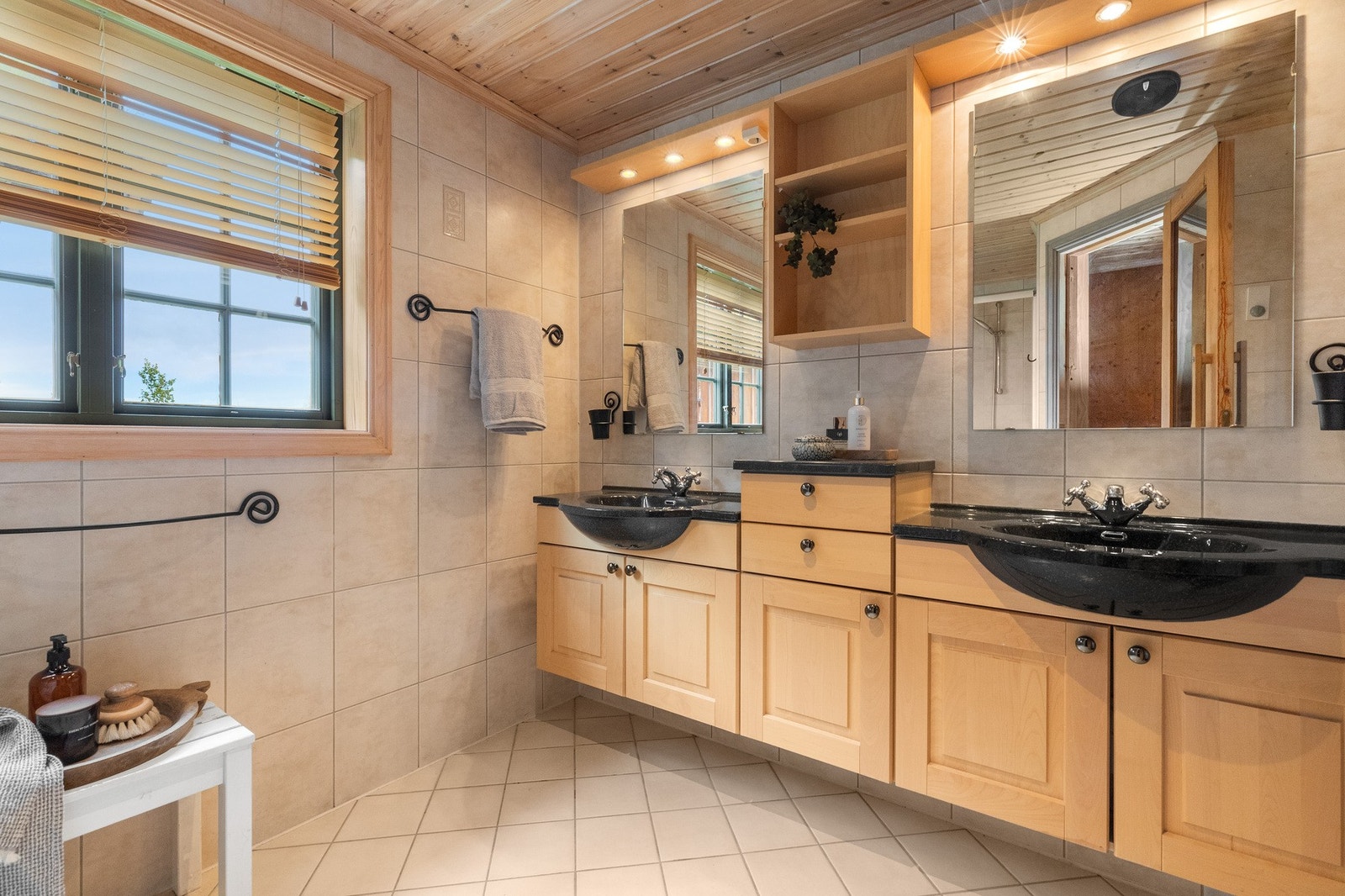 Badet i første etasje har flislagte overflater på vegger og gulv i en lys fargetone Galleribilde