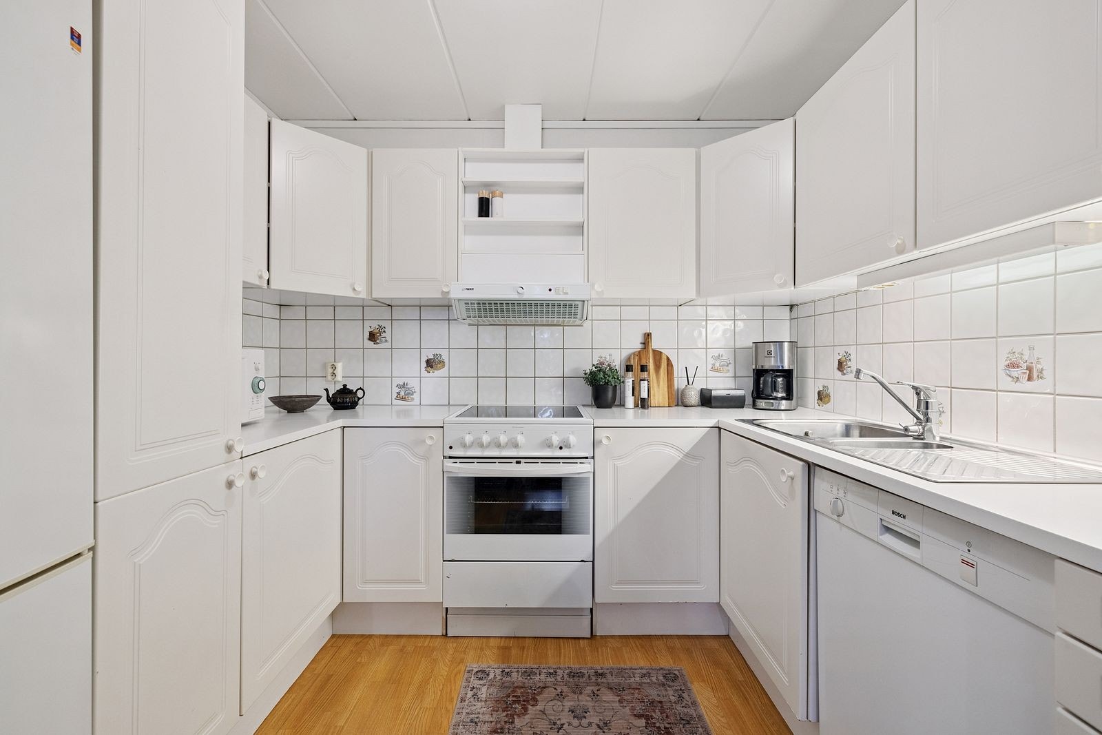 Praktisk kjøkken fra byggeår, hvite profilerte fronter og rikelig med skapplass. Galleribilde