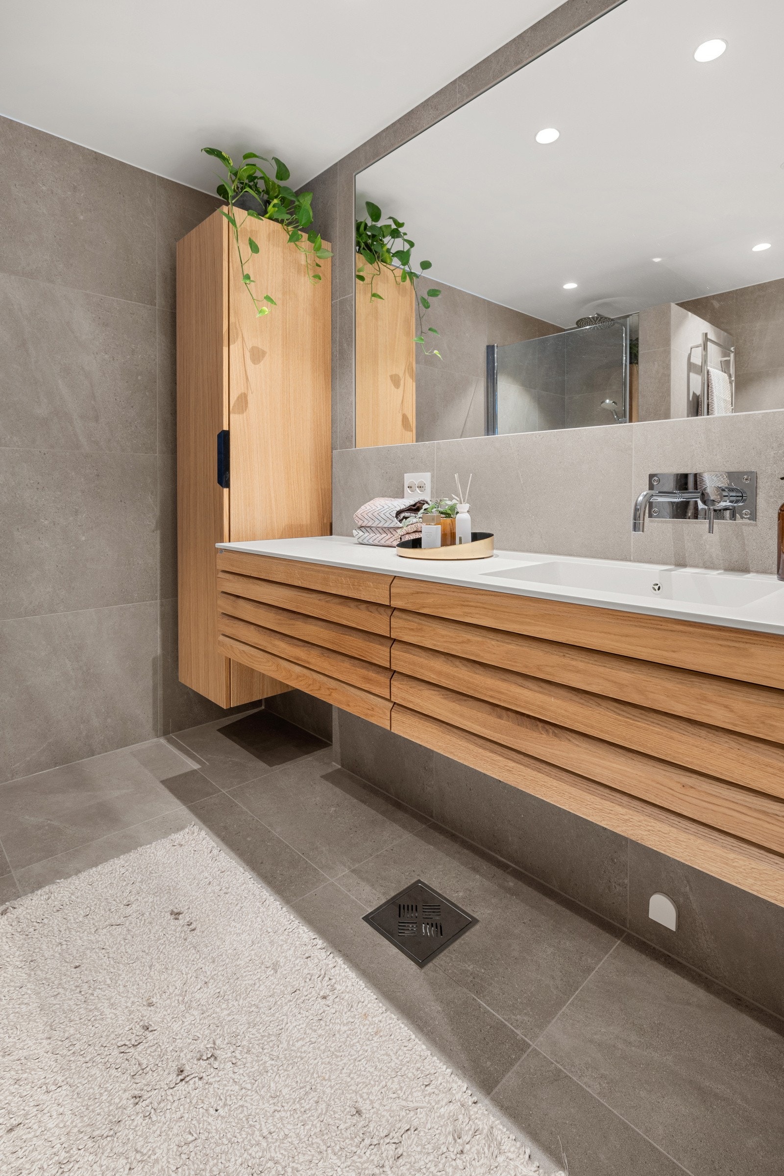 Baderommet inneholder Coran benkeplate med integrert dobbel servant, høyskap, innbygd servantbatteri, Geberit veggmontert spyle/tørk toalett, dusjnisje, elektrisk håndklevarmer, veggspeil og geberit Duofix TEK sisterne. Galleribilde