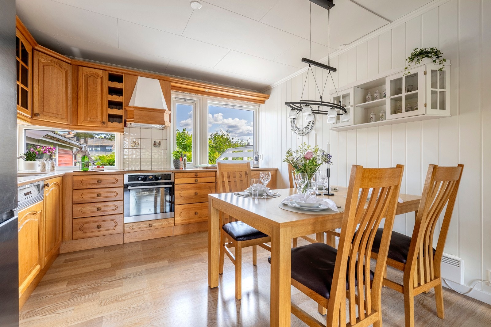 Kjøkkenet har et klassisk design med gode benkeflater og rikelig med oppbevaringsplass. Innredningen har gylne, profilerte eikefronter, vitrinedører og lys laminatbenkeplate med nedfelt kum i stål. Galleribilde