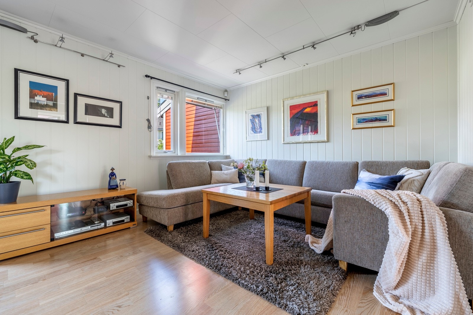 Stuen oppleves som luftig, romslig og innbydende, og ligger i dels åpen løsning med kjøkkenet. Dagslyset som strømmer inn via store vinduer gjenspeiles fint i de hvitmalte overflatene. Galleribilde