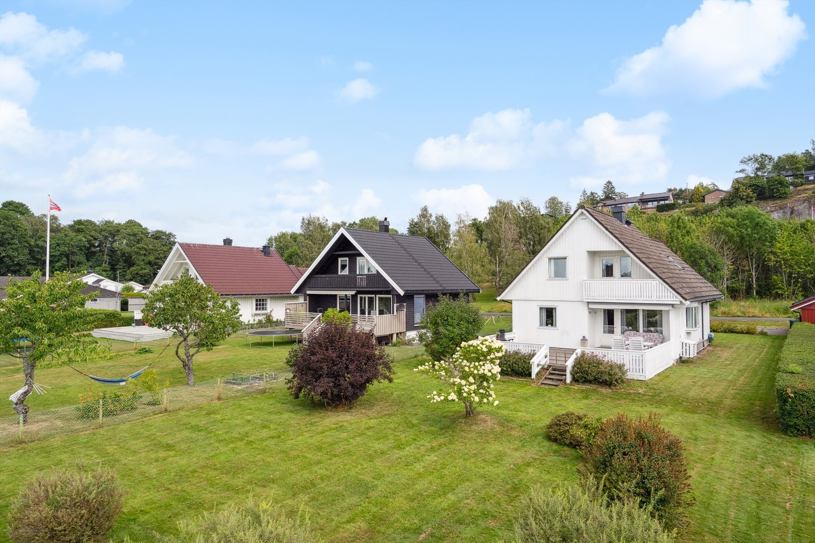 Eiet tomt med plen, beplantning og fine uteplasser. Dobbel garasje og gruset gårdsplass. Galleribilde