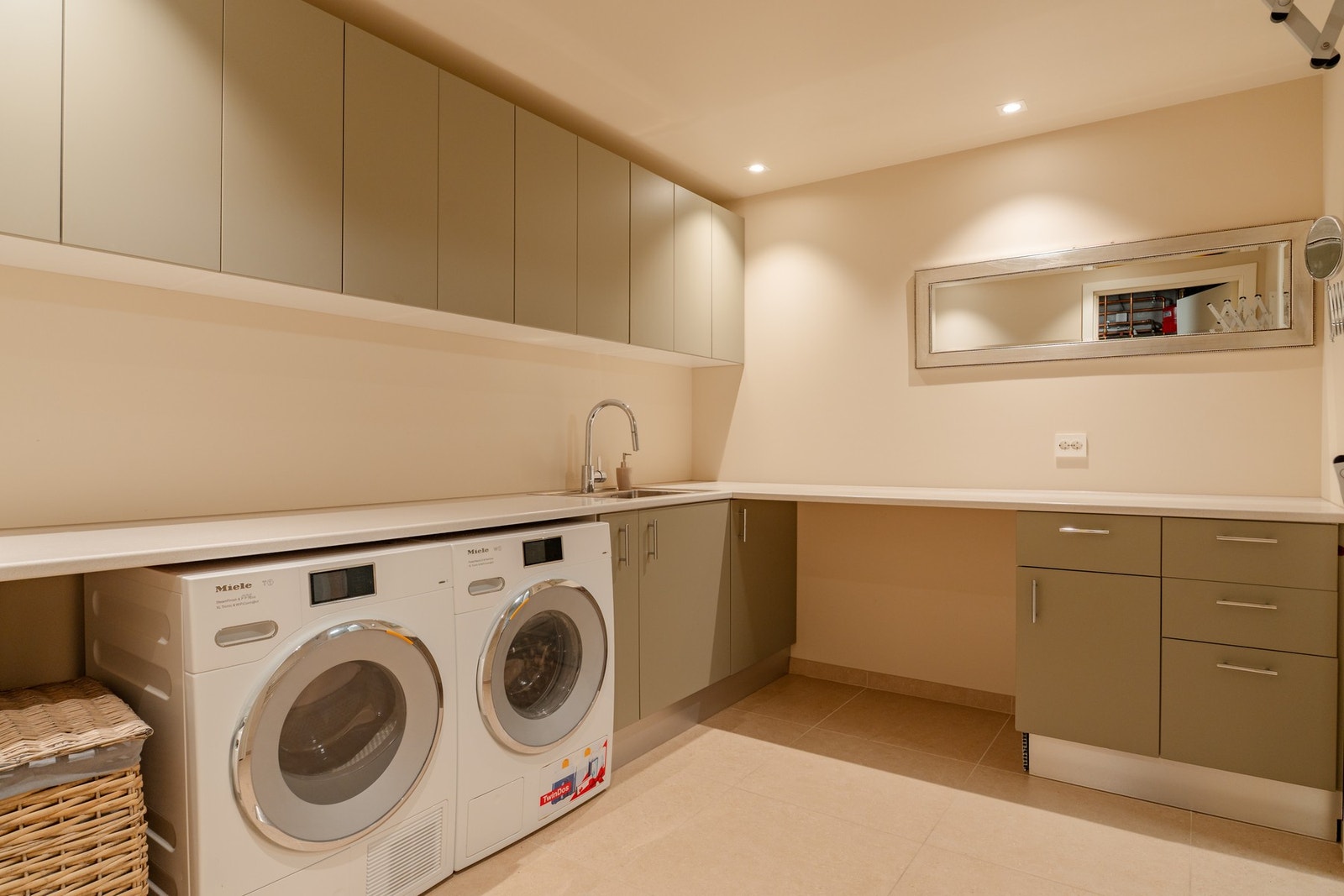 Tidsmessig velutrustet vaskerom med godt med skap, overskap og innredning, grå tidsmessige fronter. Galleribilde