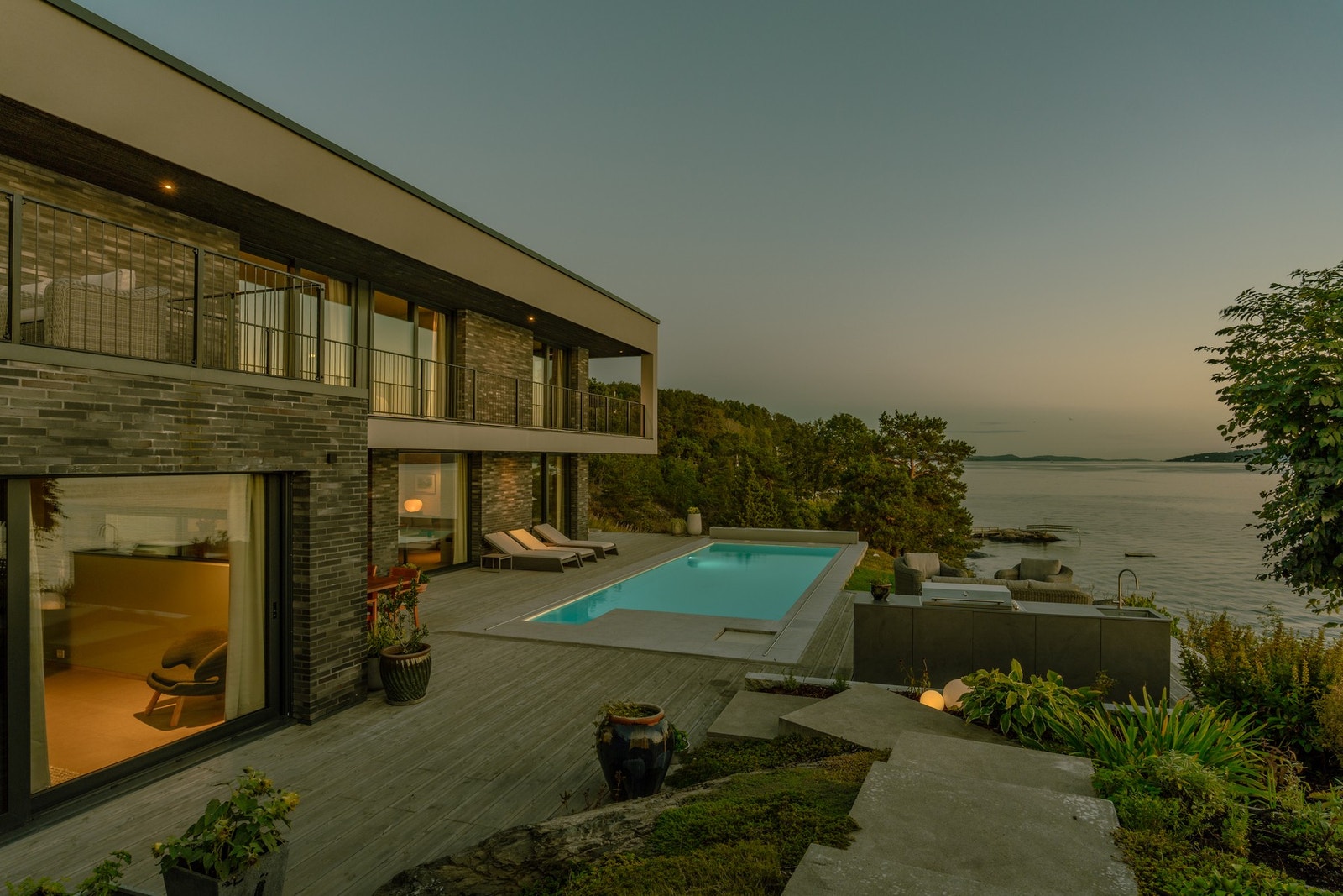 Et uteområde som kombinerer moderne luksus med naturskjønn beliggenhet - en sjelden opplevelse rett ved vannkanten. Galleribilde