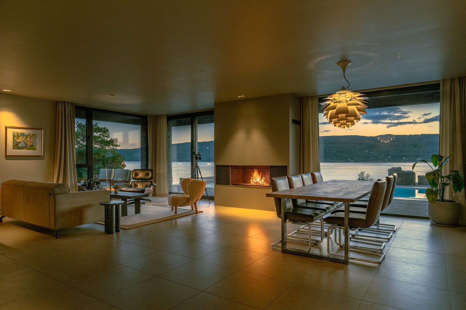 Et rom som kombinerer varme og eleganse - ildsted, store vindusflater og direkte nærhet til fjorden. Galleribilde