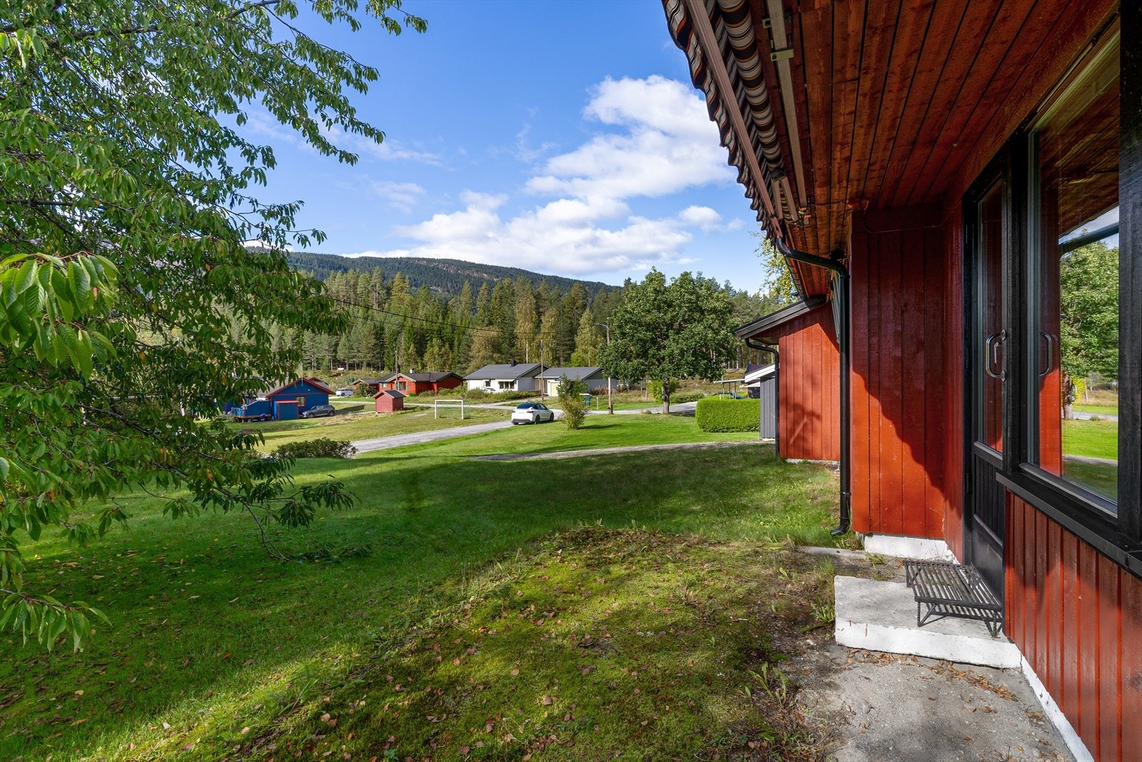 Tomten er lett skrånet og opparbeidet med gressplen, samt en gruset gårdsplass. Galleribilde