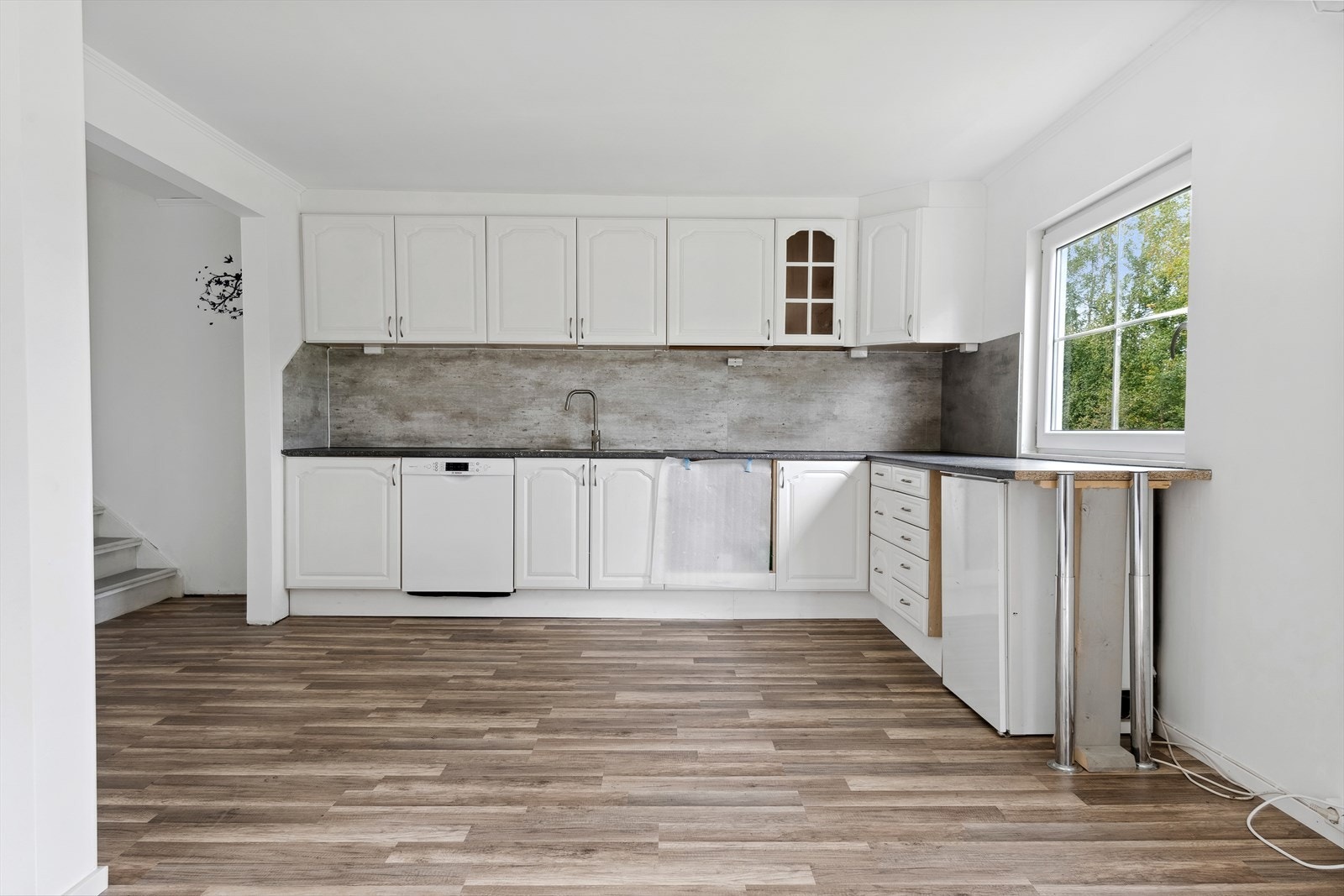 Kjøkkeninnredning som er noen år av laminerte skrog med malte profilerte fronter og laminert benkeplate. Galleribilde