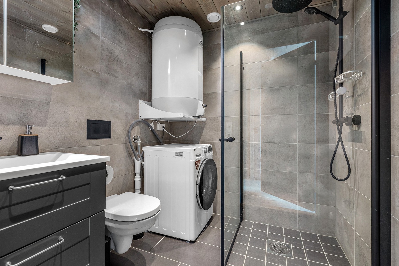 Delikat flislagt bad med dushjørne og opplegg for vaskemaskin. Galleribilde