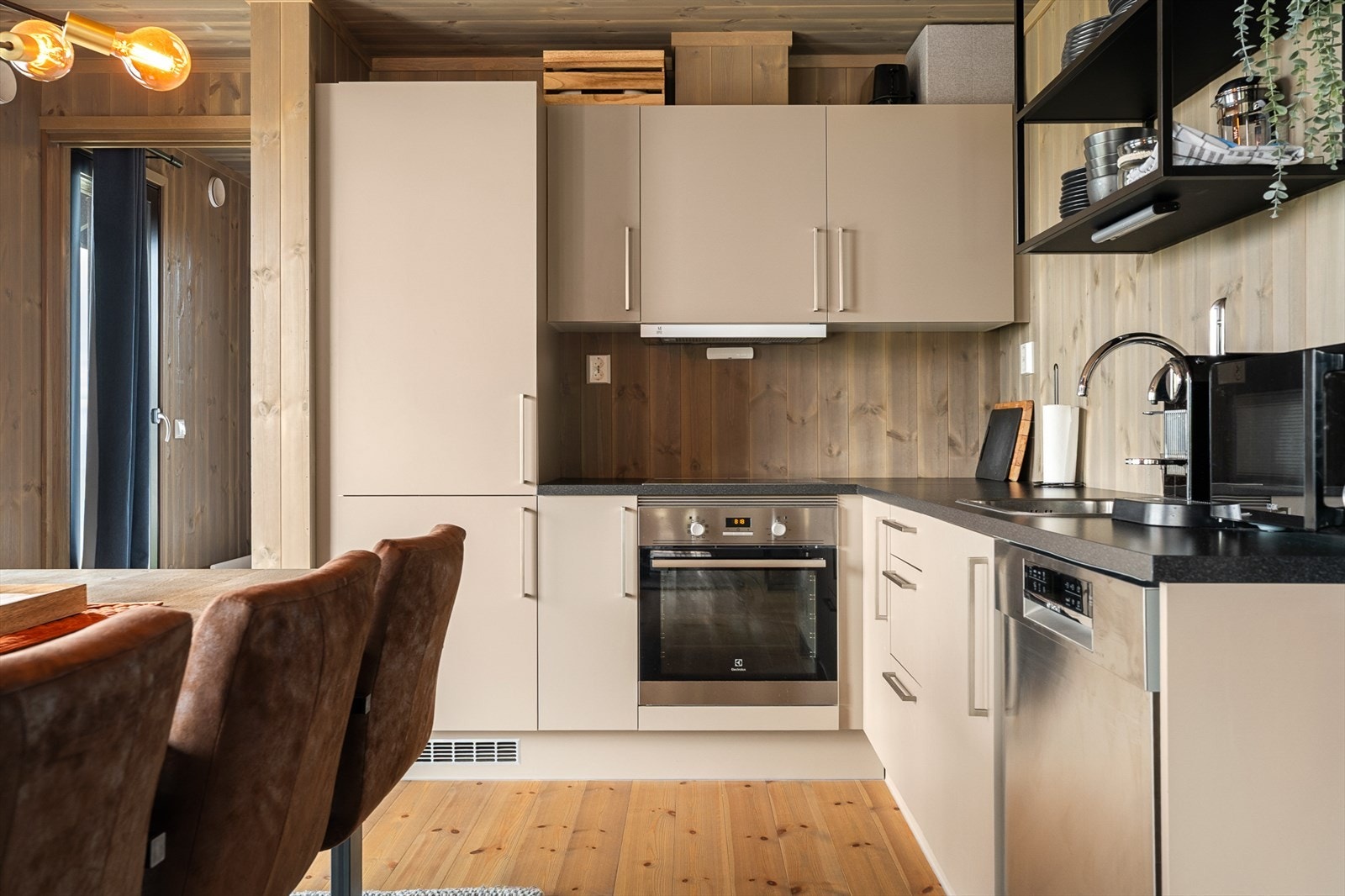 Kjøkken med glatte fronter, laminerte benkeplater og nedfelt oppvaskkum i børstet rustfritt stål med 1-greps blandebatteri. Galleribilde