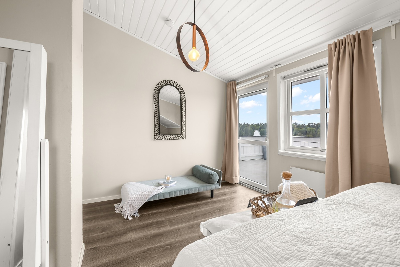 Fra dette rommet er det direkte tilgang til både garderobeløsning og bad, noe som gir en praktisk og funksjonell planløsning. I tillegg har hovedsoverommet utgang til en stor terrasse, som fungerer som et privat uteområde med flott utsyn. Galleribilde