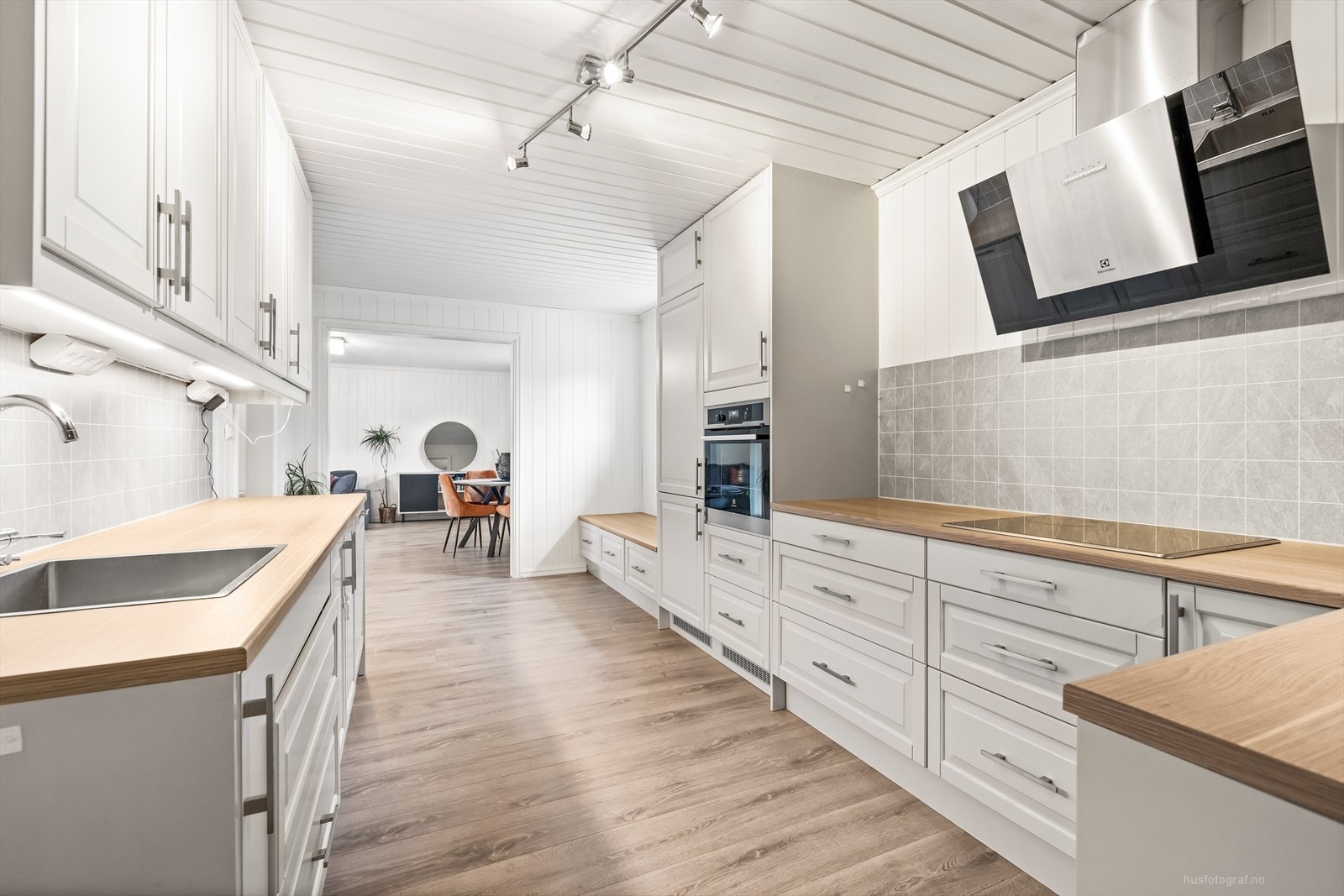 Lys og moderne kjøkkenløsning med integrerte hvitevarer og god benkeplass. Galleribilde