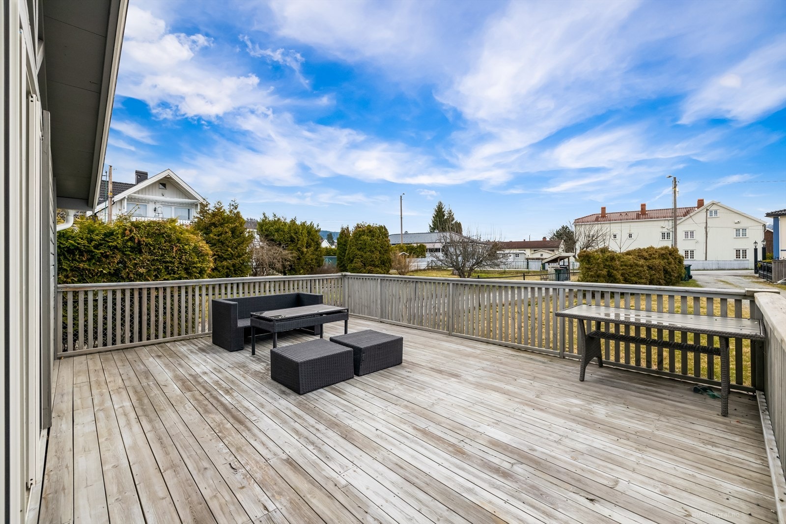 Romslig terrasse med god plass for utemøbler, ideell for sosiale sammenkomster, omgitt av et fredelig nabolag. Galleribilde