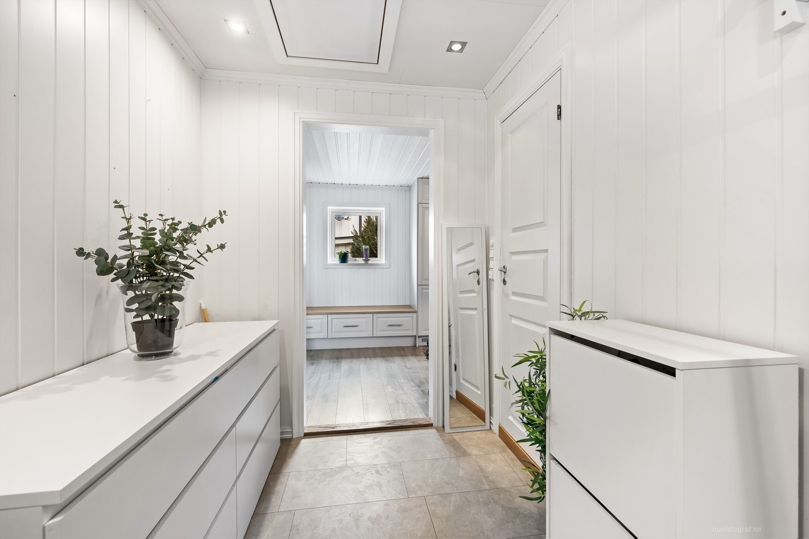 Lys og innbydende entré med moderne oppbevaringsløsninger og delikate, lyse overflater. Galleribilde