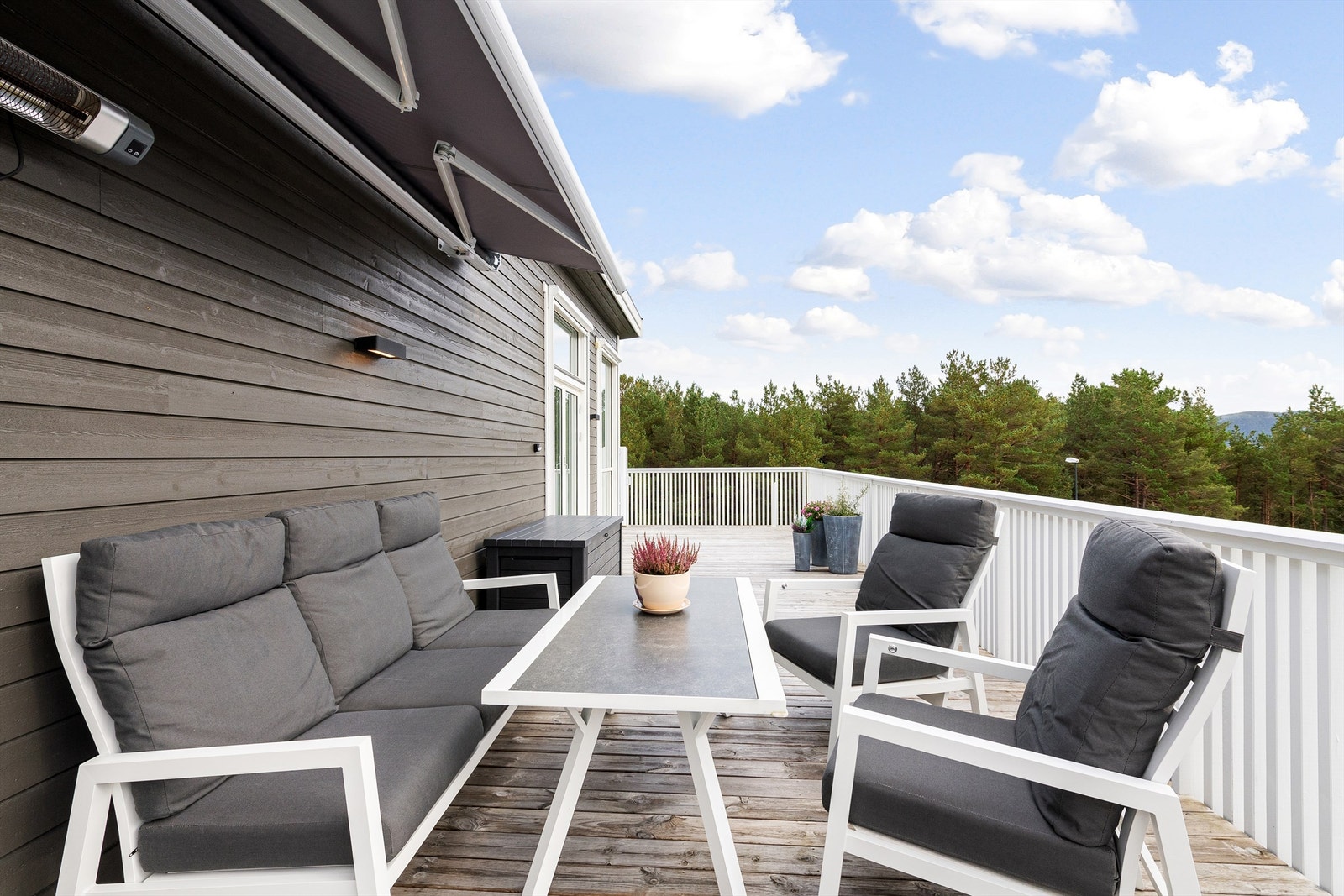 Deler av balkongen i 2. etasje med markise og varmelampe på vegg Galleribilde