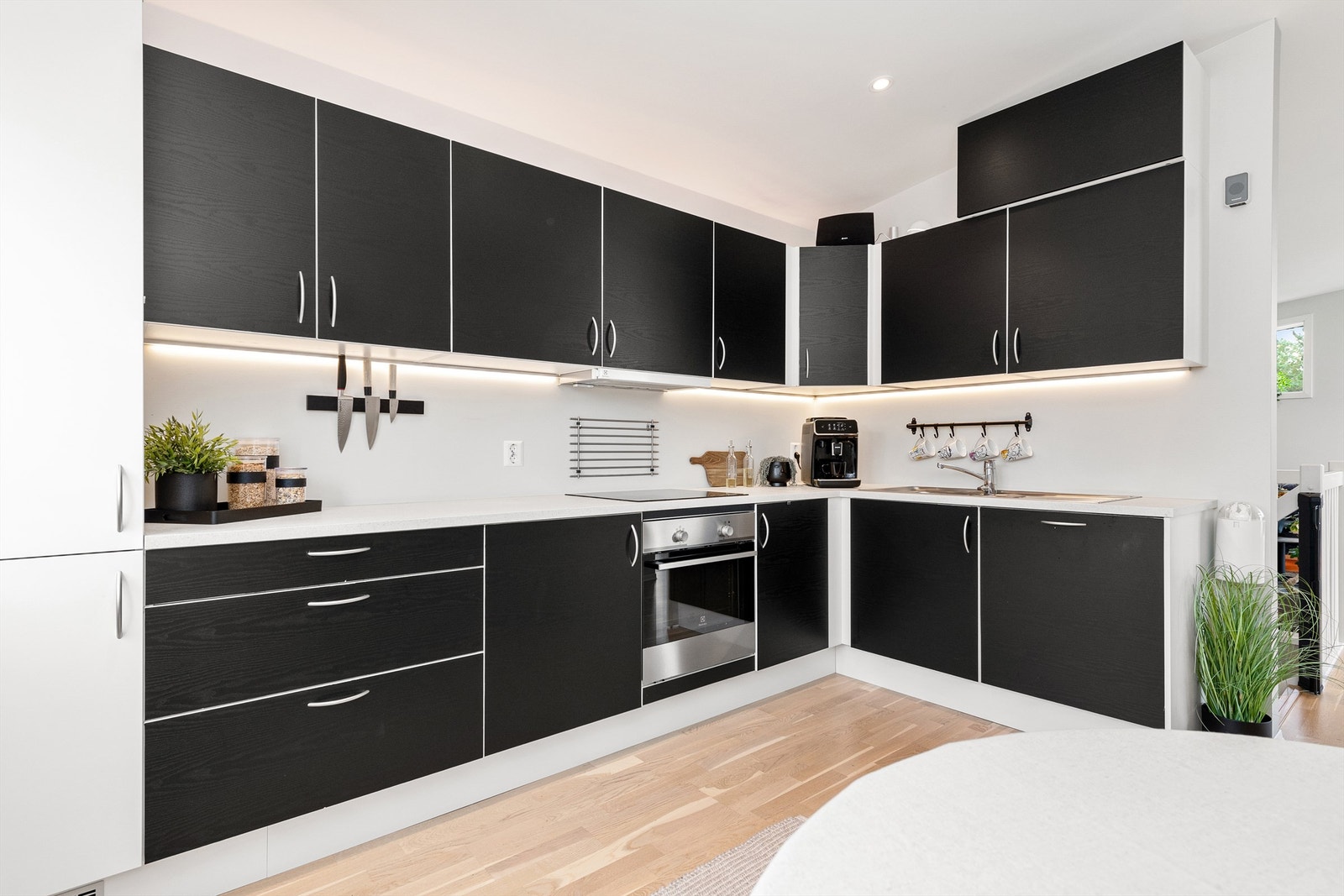 Kjøkkeninnredningen er fra Aubo og har sorte glatte fronter og benkeplate av laminat Galleribilde