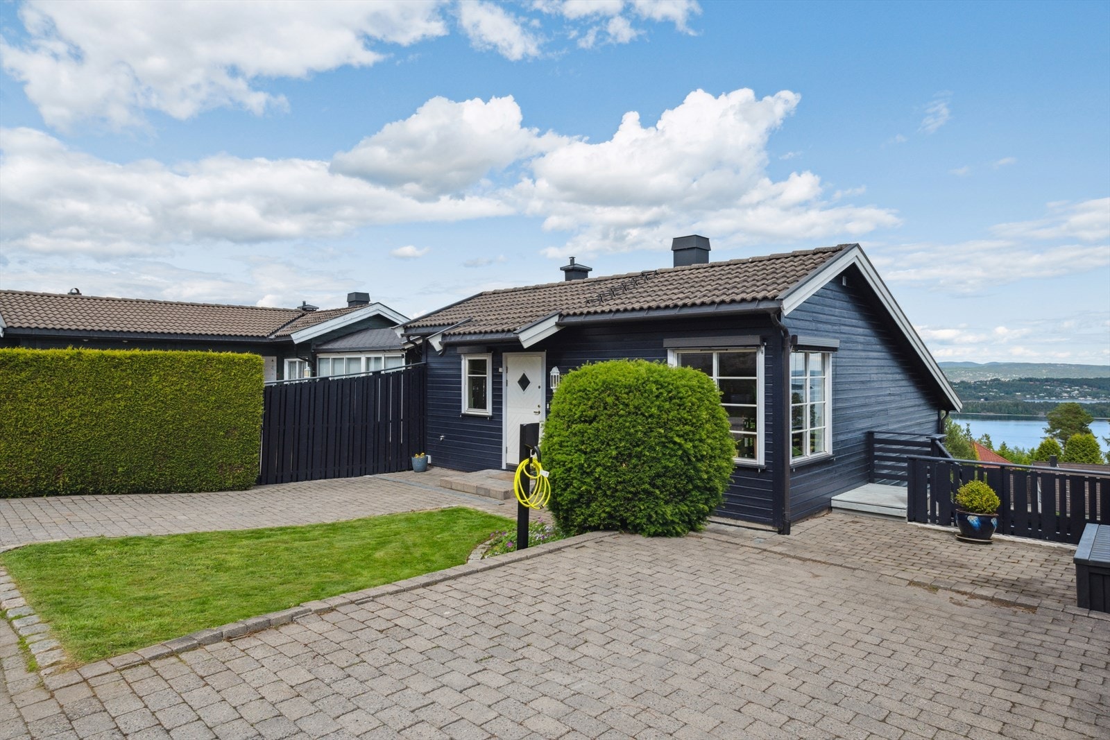 Steinbelagt gårdsplass med elbillader og god plass for parkering. Galleribilde